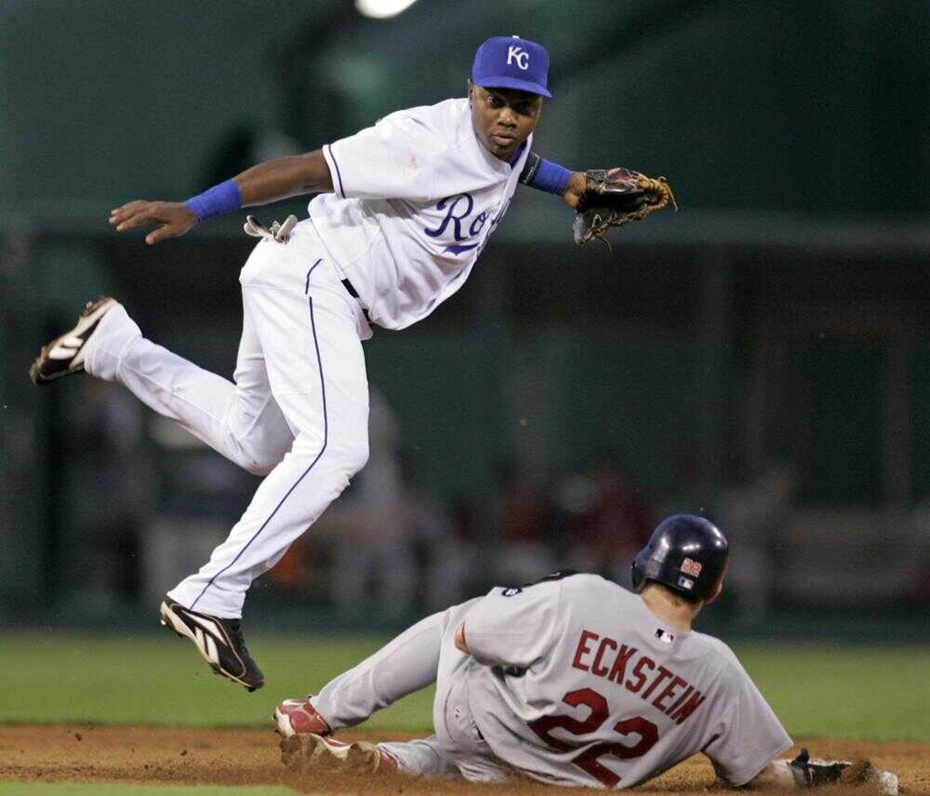 Cardinals baserunner David Eckstein unsuccessfully tried to break up a double play as Royals second baseman Esteban German threw to first during their game Tuesday in Kansas City. (Charlie Riedel ~ Associated Press)