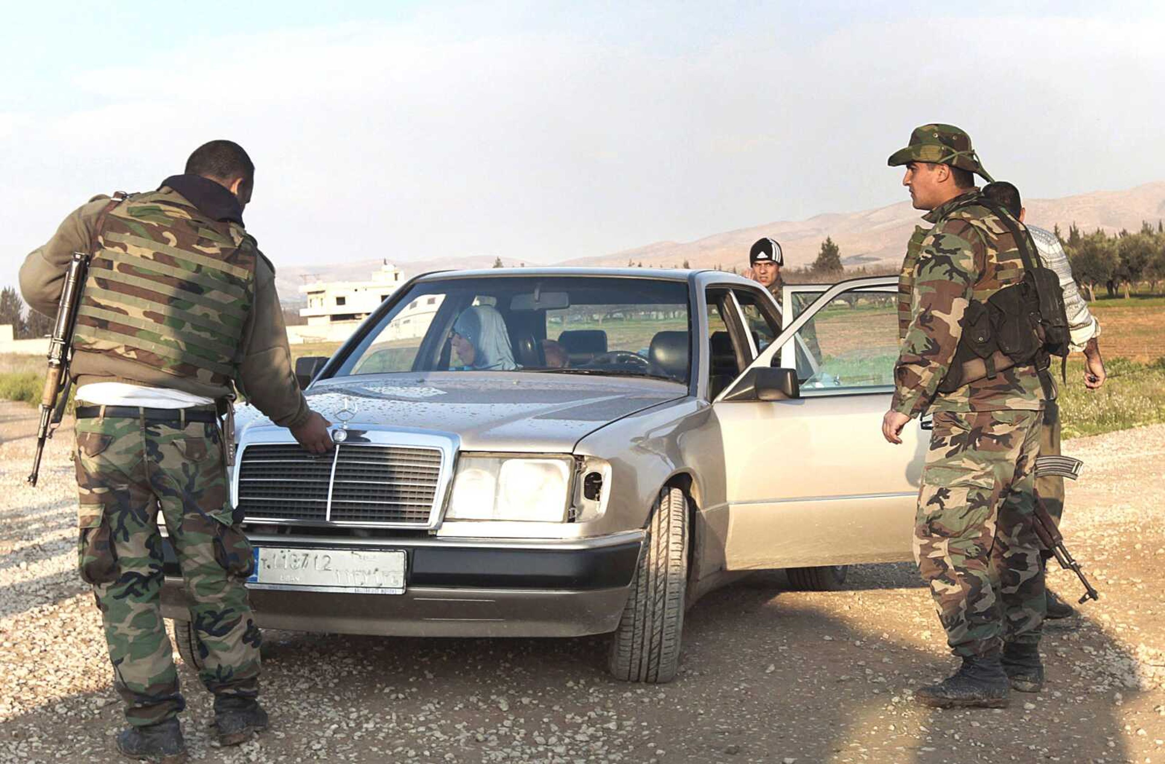 Lebanese army soldiers search a car Tuesday during a raid at the Lebanese-Syrian border town of Qaa in northeastern Lebanon. Syria has accepted a peace plan by U.N. envoy Kofi Annan that includes a government cease-fire, but the bloodshed persisted Tuesday as intense clashes between soldiers and rebels spilled across the border into Lebanon, officials said. (Hussein Malla ~ Associated Press)