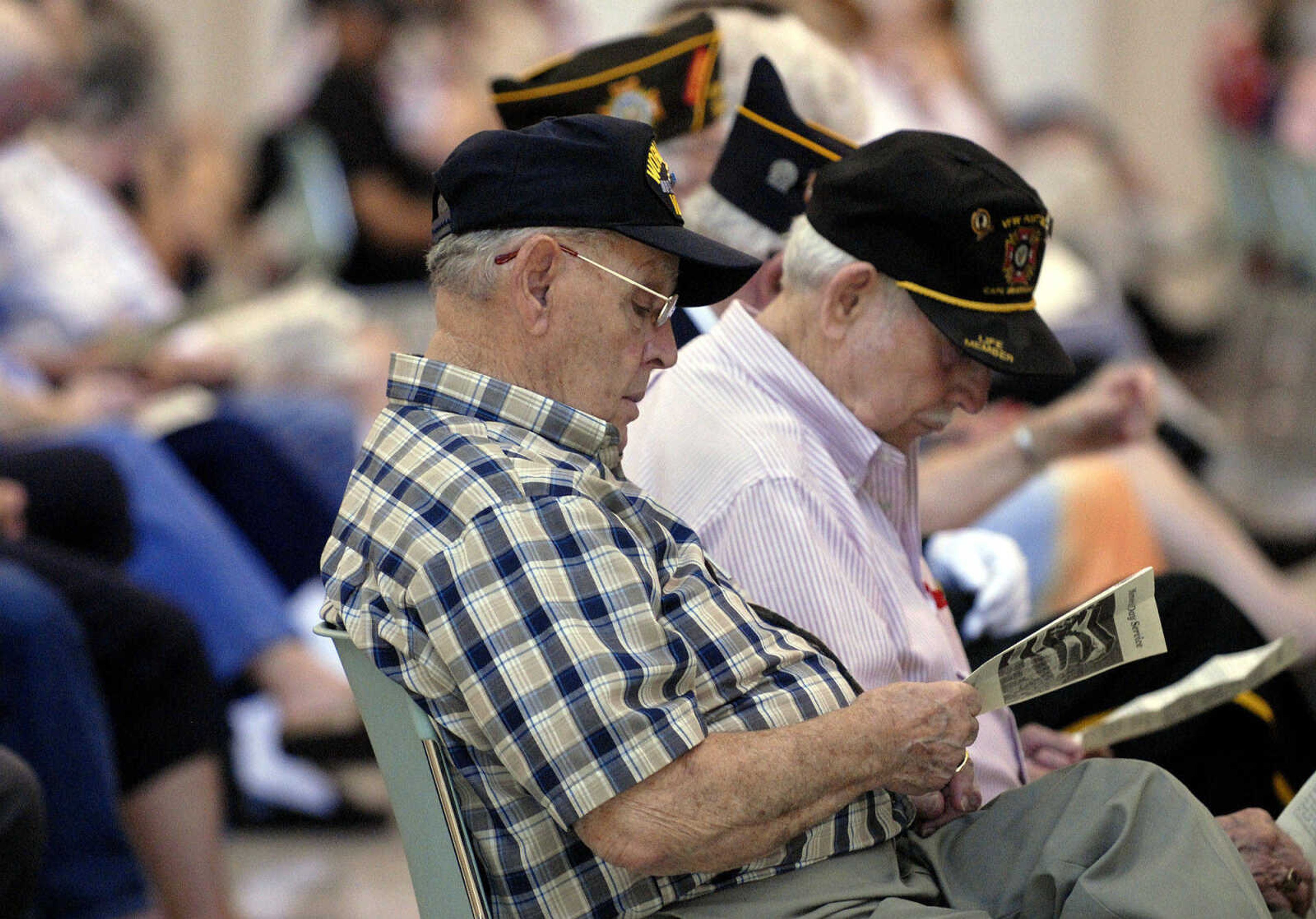 LAURA SIMON~lsimon@semissourian.com
Veterans browse through the program during the Memorial Day service Monday, May 30, 2011 at the Osage Centre in Cape Girardeau.