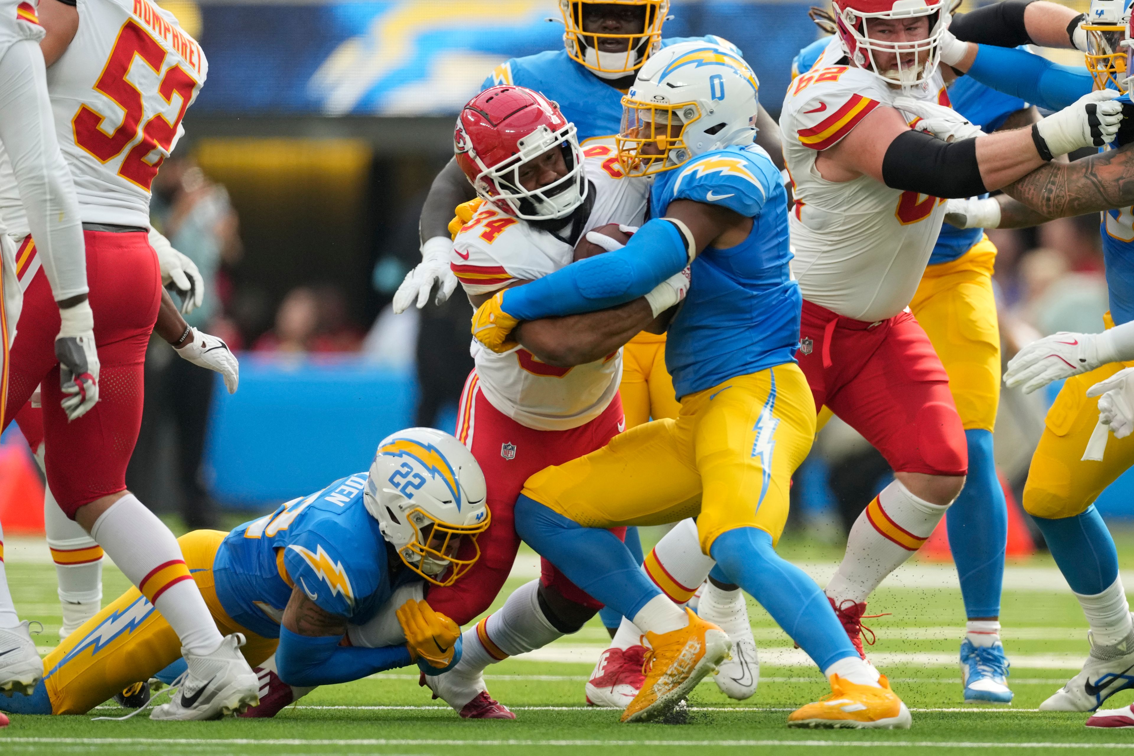 Kansas City Chiefs running back Samaje Perine (34) is stopped by Los Angeles Chargers defensive back Elijah Molden (22) and linebacker Daiyan Henley (0) during the first half of an NFL football game Sunday, Sept. 29, 2024, in Inglewood, Calif. (AP Photo/Ashley Landis)