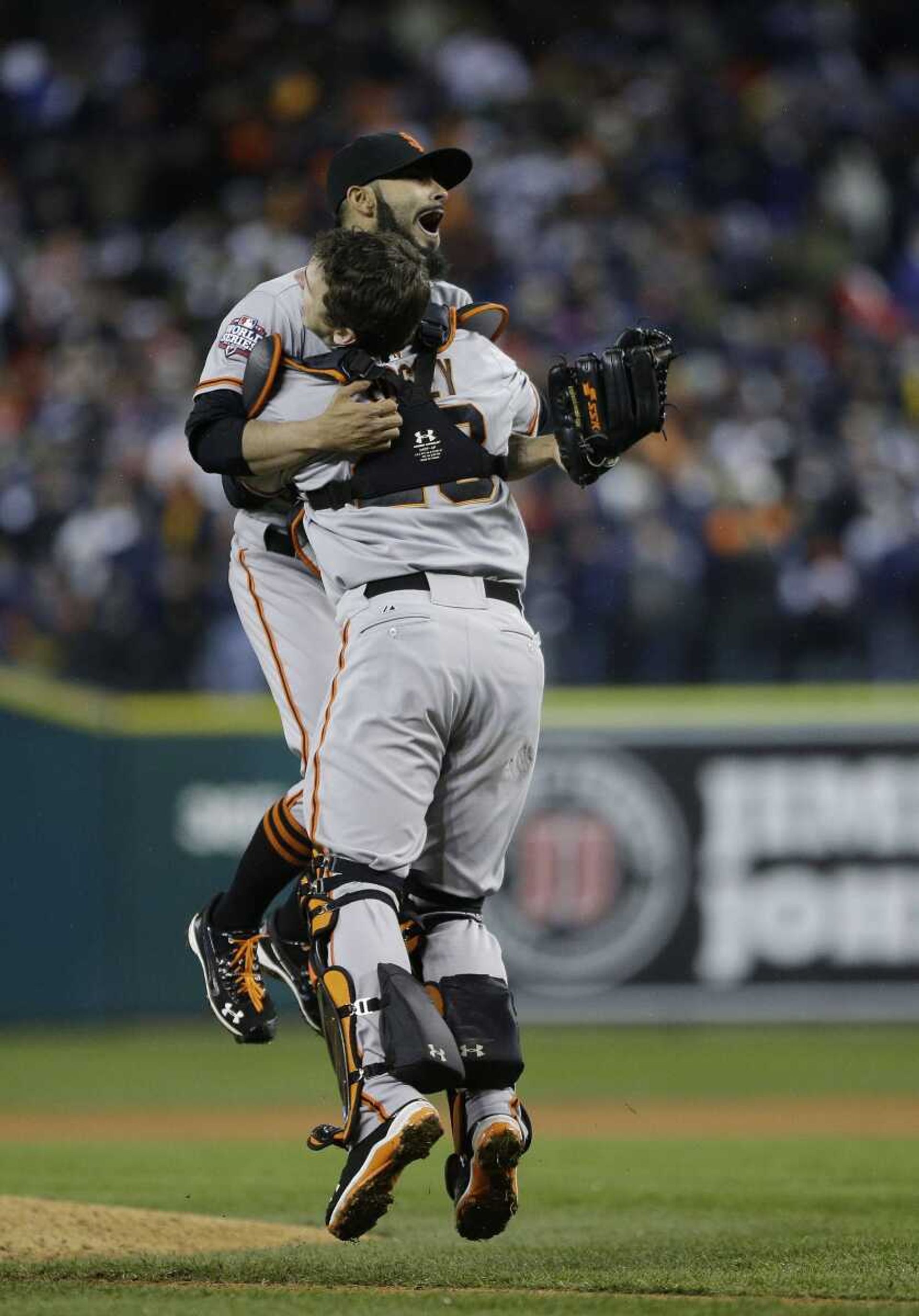 The Giants&#8217; Sergio Romo and catcher Buster Posey celebrate after defeating the Tigers 4-3 in Game 4 of the World Series. (Matt Slocum ~ Associated Press)