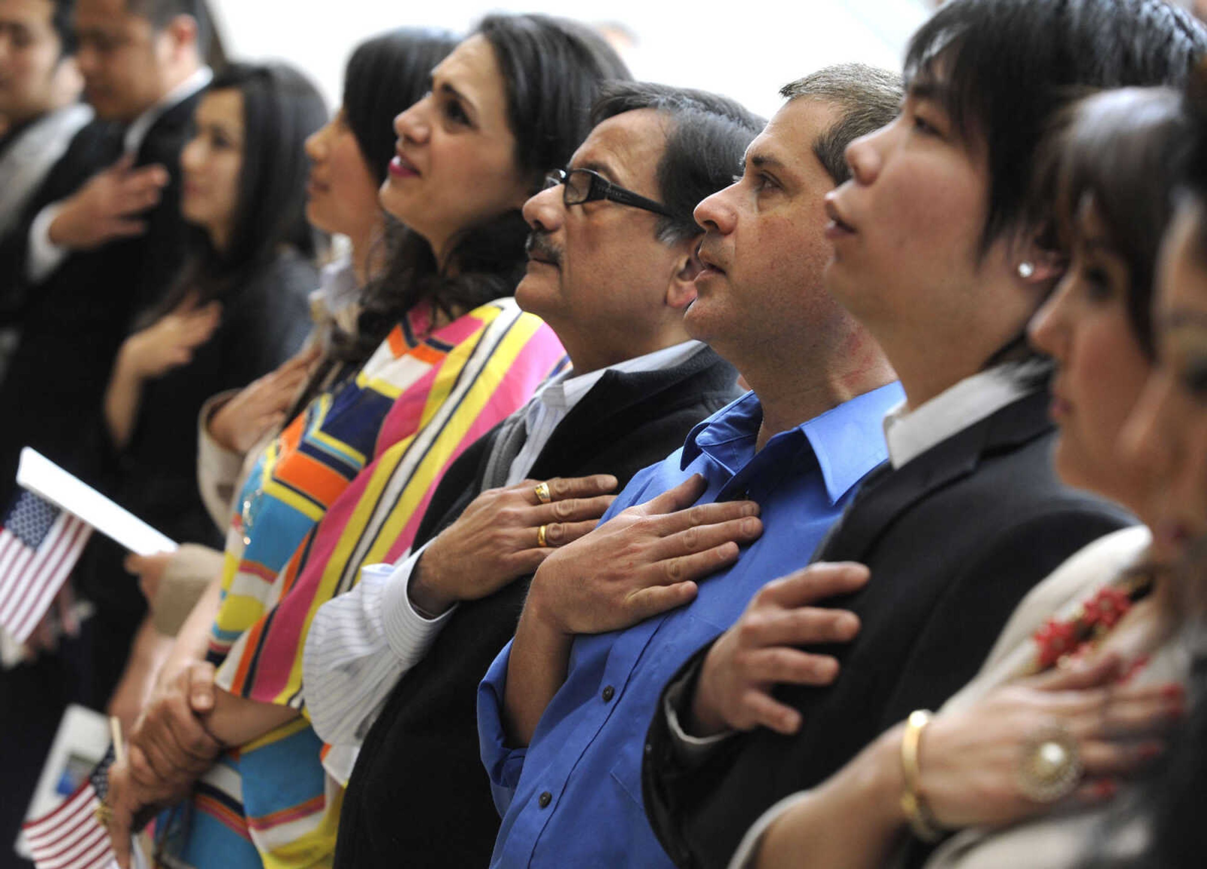 The petitioners stand for the National Anthem during a naturalization ceremony Friday, May 2, 2014 at the Rush H. Limbaugh Sr. U.S. Courthouse in Cape Girardeau.