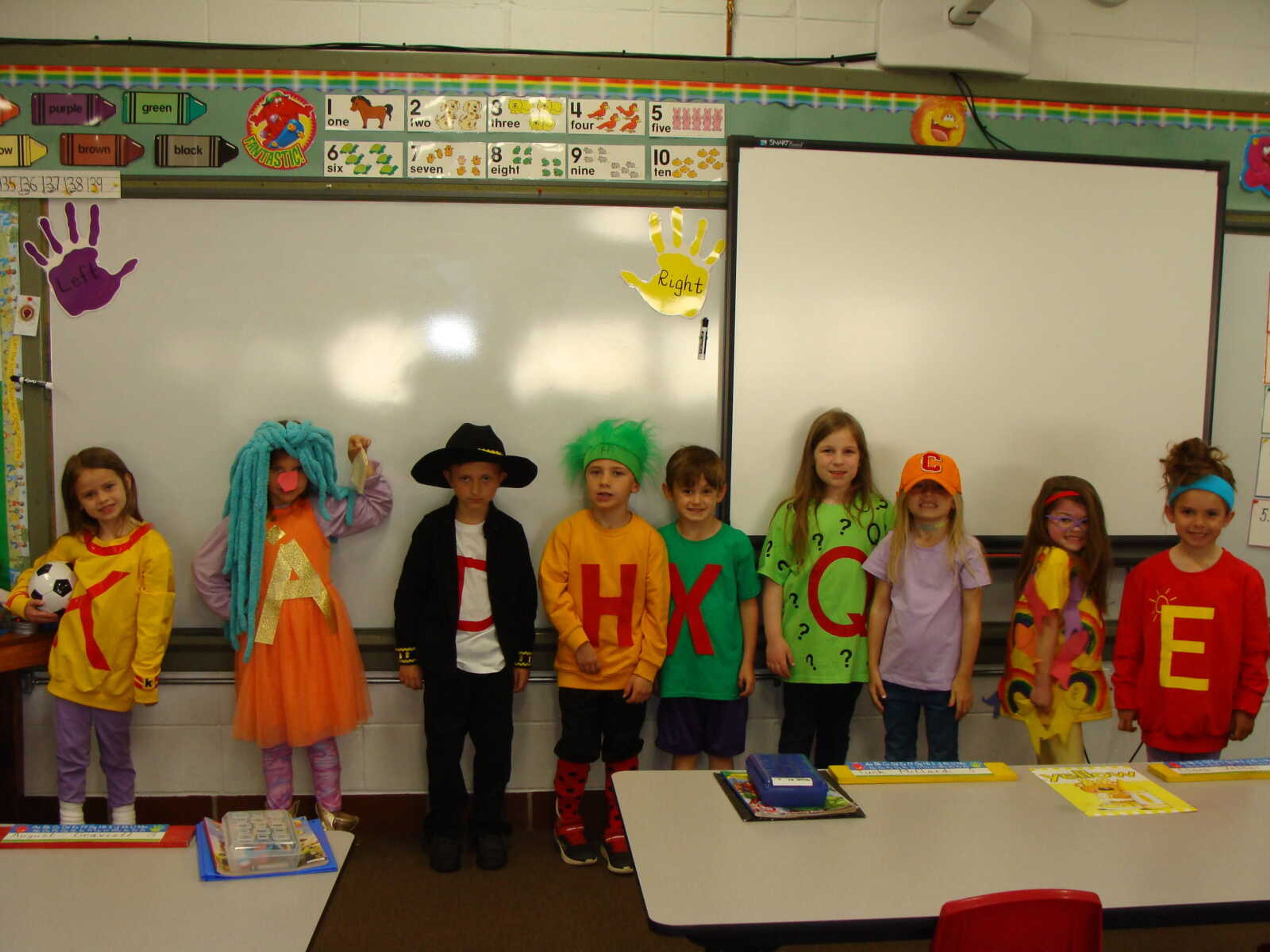 The kindergarten class shows off the letter people outfits they created.  Left to right are Berkley Dennis-Ms. K (Kaboom Kick);  Presley Pinkston-Ms. A (A'Choo); Jude Seabaugh-Mr. D (Dazzling Dance);  August Graviett-Mr. H (Happy Hair);  
Tuck McClard-Mr. X (Mixed Up);  Clara Vetter-Mr. Q (Quiet Question); Caroline Kyle-Mr. C (Colossal Cap);  Sadie Seyer-Mr. R (Rainbow Ribbon); & Caroline Eskew-Ms. E (Exercise Energy).
