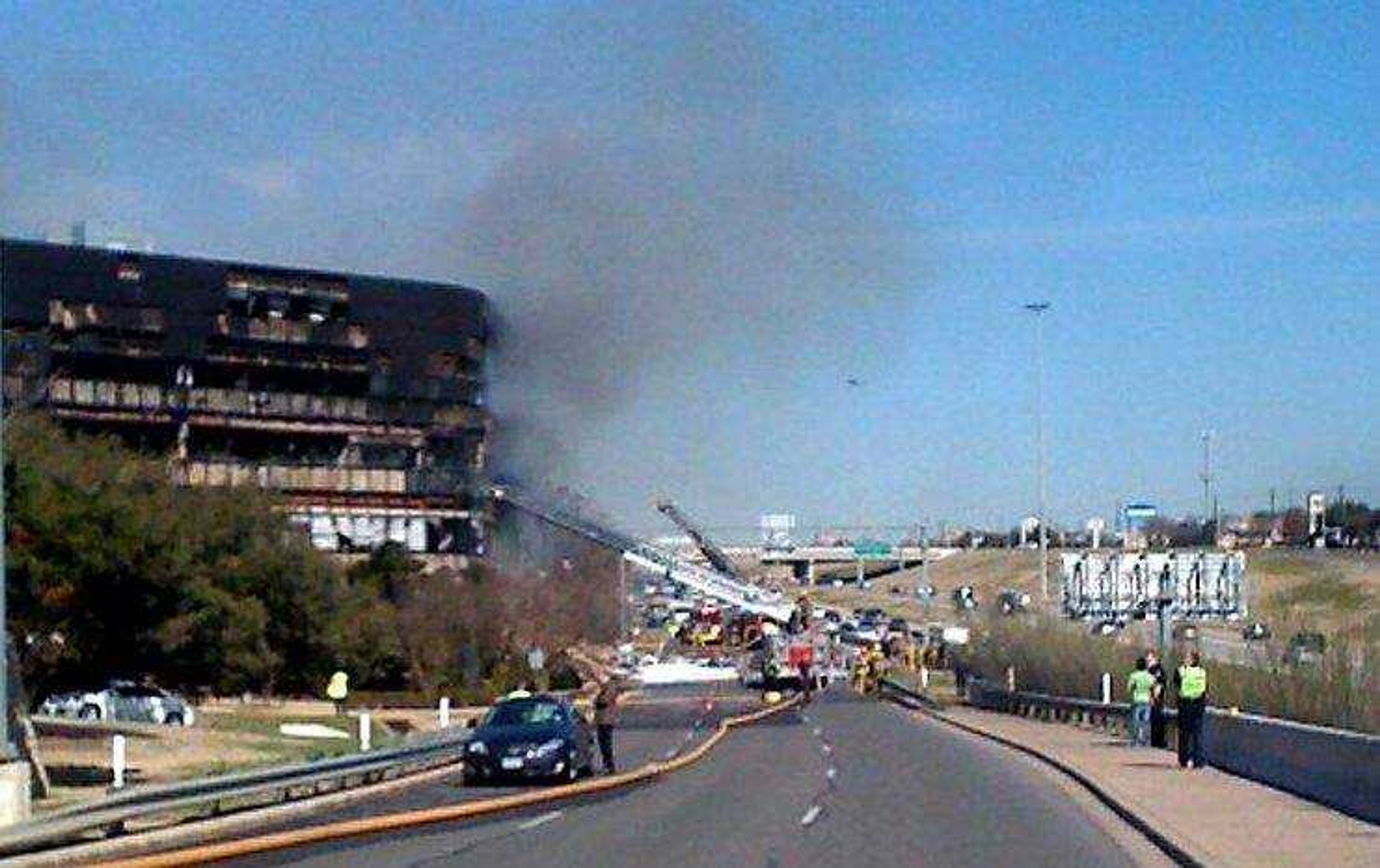 Smoke billows from a seven-story building after a small private plane crashed into the building  in Austin, Texas on Thursday Feb. 18, 2010. (AP Photo/Austin American-Statesman, Jay Janner/)