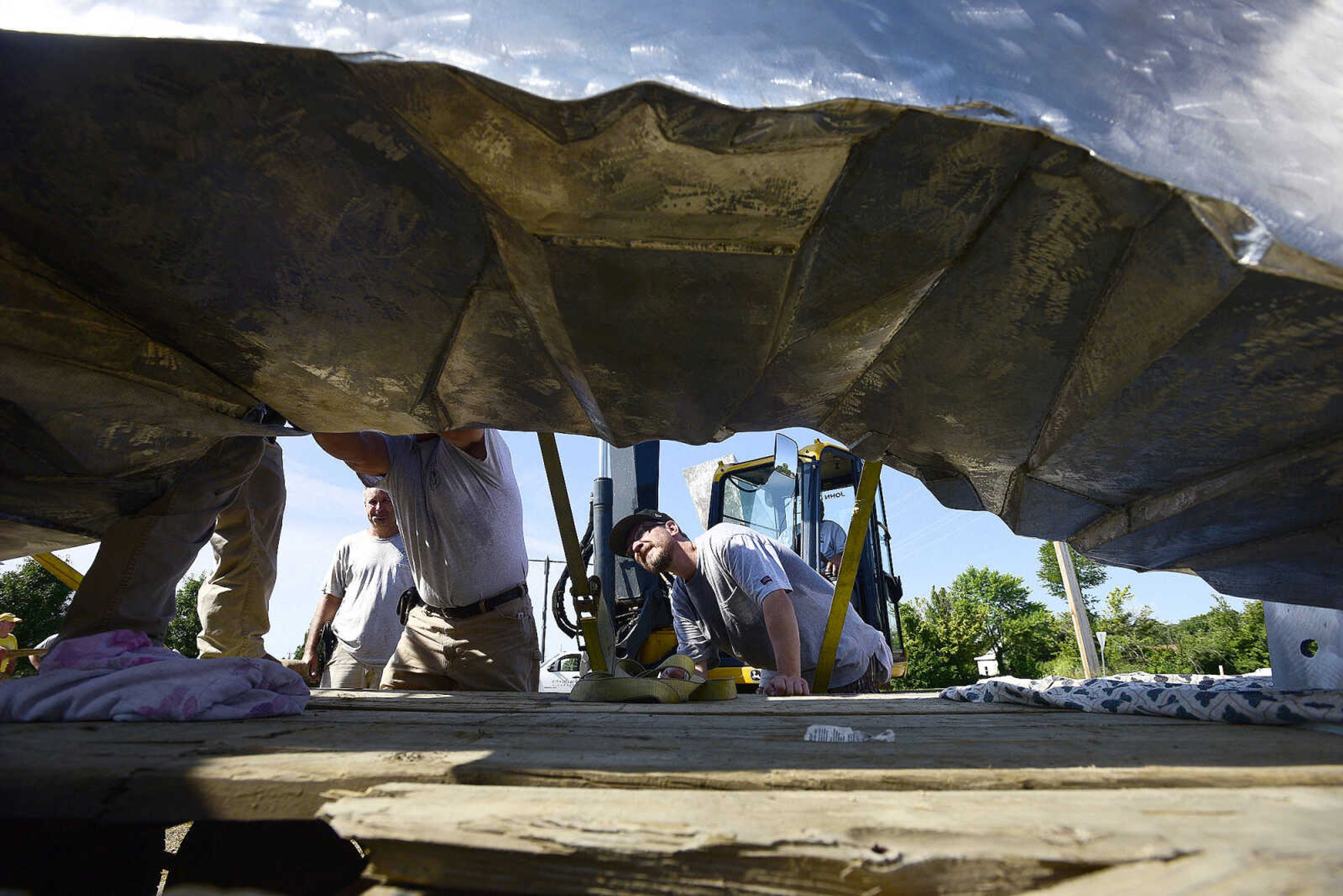 Chris Wubbena looks under his 14-foot sculpture as it lays on its side before its installation in the Fountain Street roundabout on Monday, July 24, 2017, near the River Campus in Cape Girardeau.