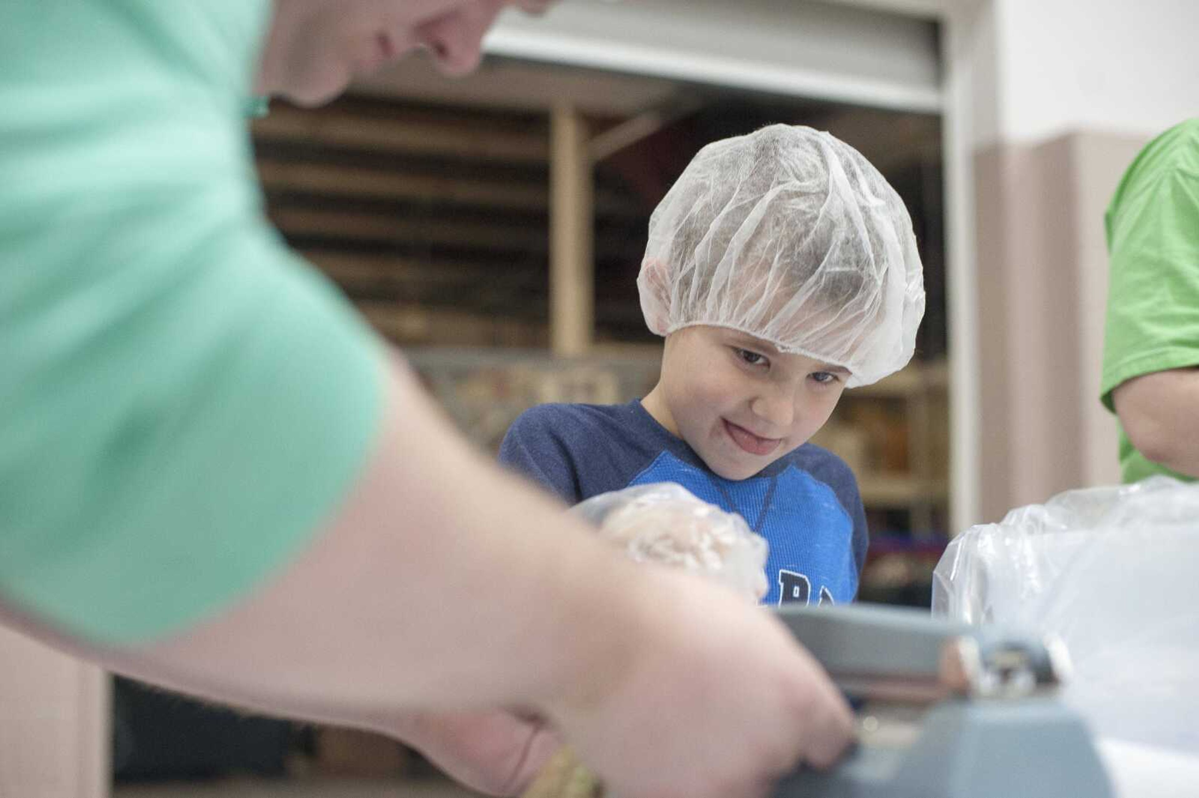 Eli Hennecke, 6, concentrates while helping other volunteers seal packages of food during a Feed My Starving Children meal packing event hosted by La Croix Church Friday, Dec. 6, 2019, at the Osage Centre in Cape Girardeau.