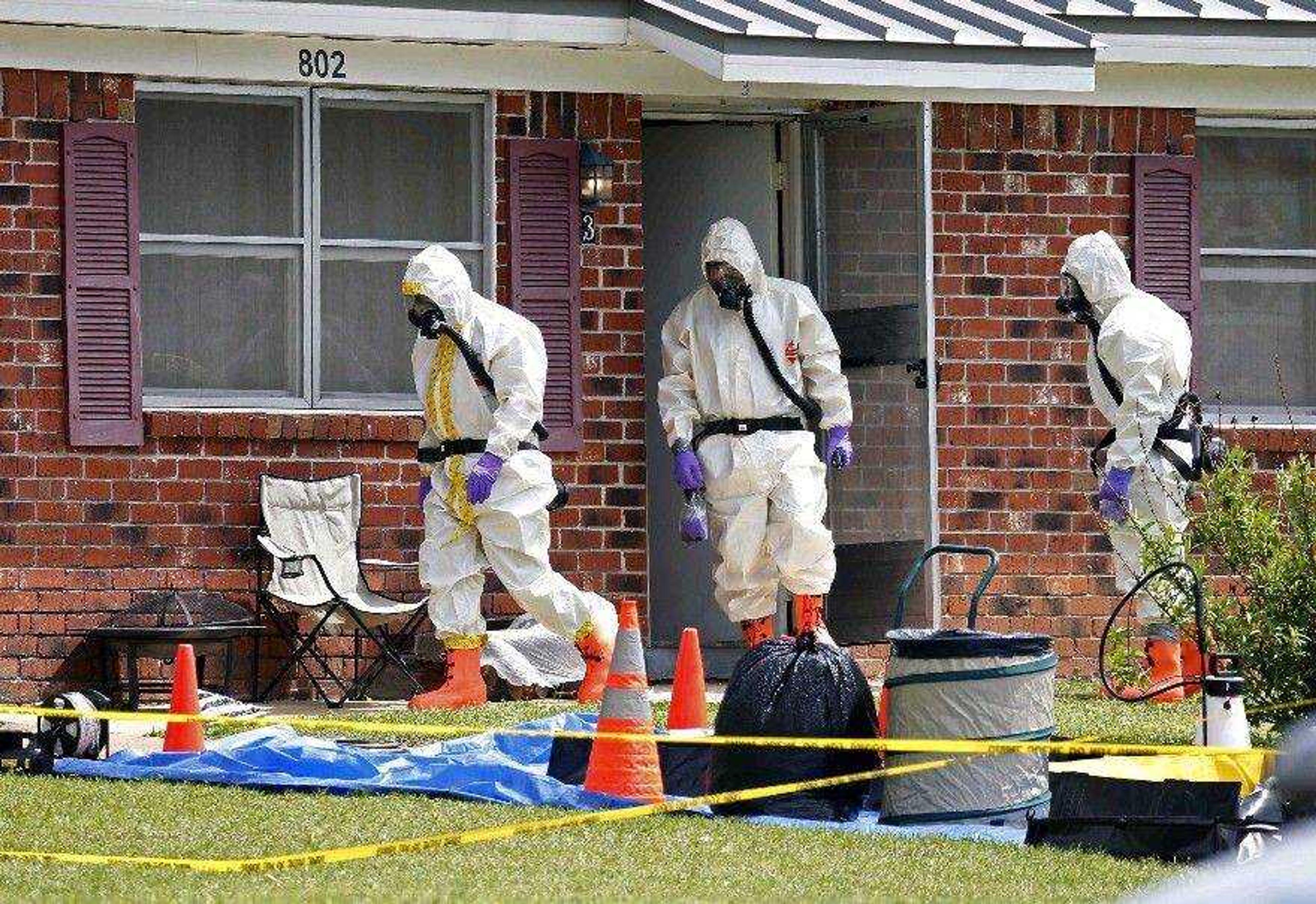 Federal agents wearing hazardous material suits and breathing apparatus on Friday exit the Corinth, Miss., home amid possessions of Paul Kevin Curtis in the town&#8217;s West Hills subdivision. (Rogelio V. Solis ~ Associated Press)