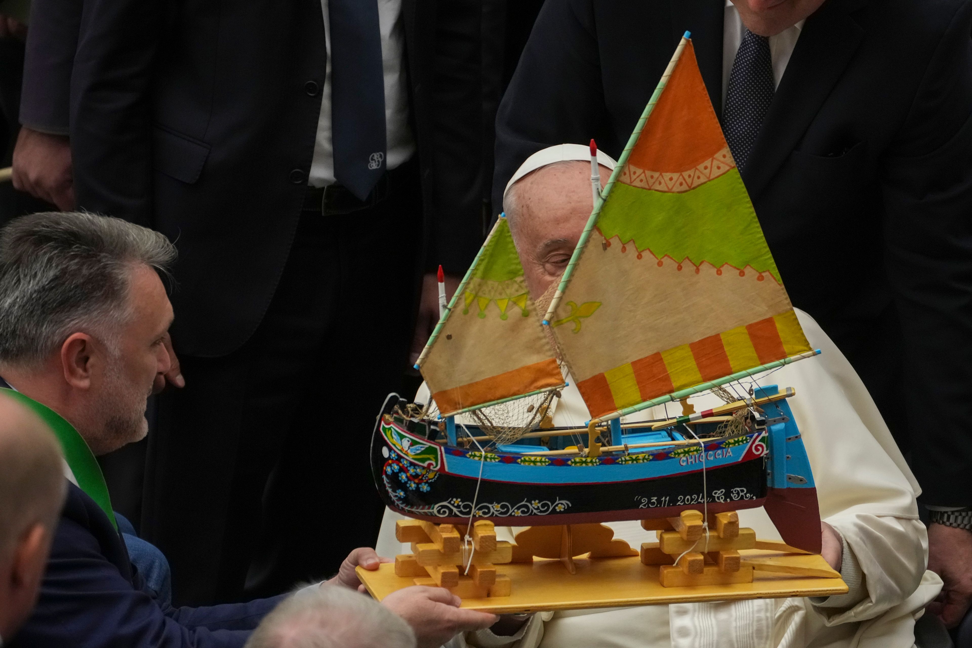 Pope Francis is presented with a model of a fishing boat during an audience with fishermen and members of the CEI, Italians Bishops Conference, in the Pope Paul VI hall at the Vatican, Saturday, Nov. 23, 2024. (AP Photo/Andrew Medichini)