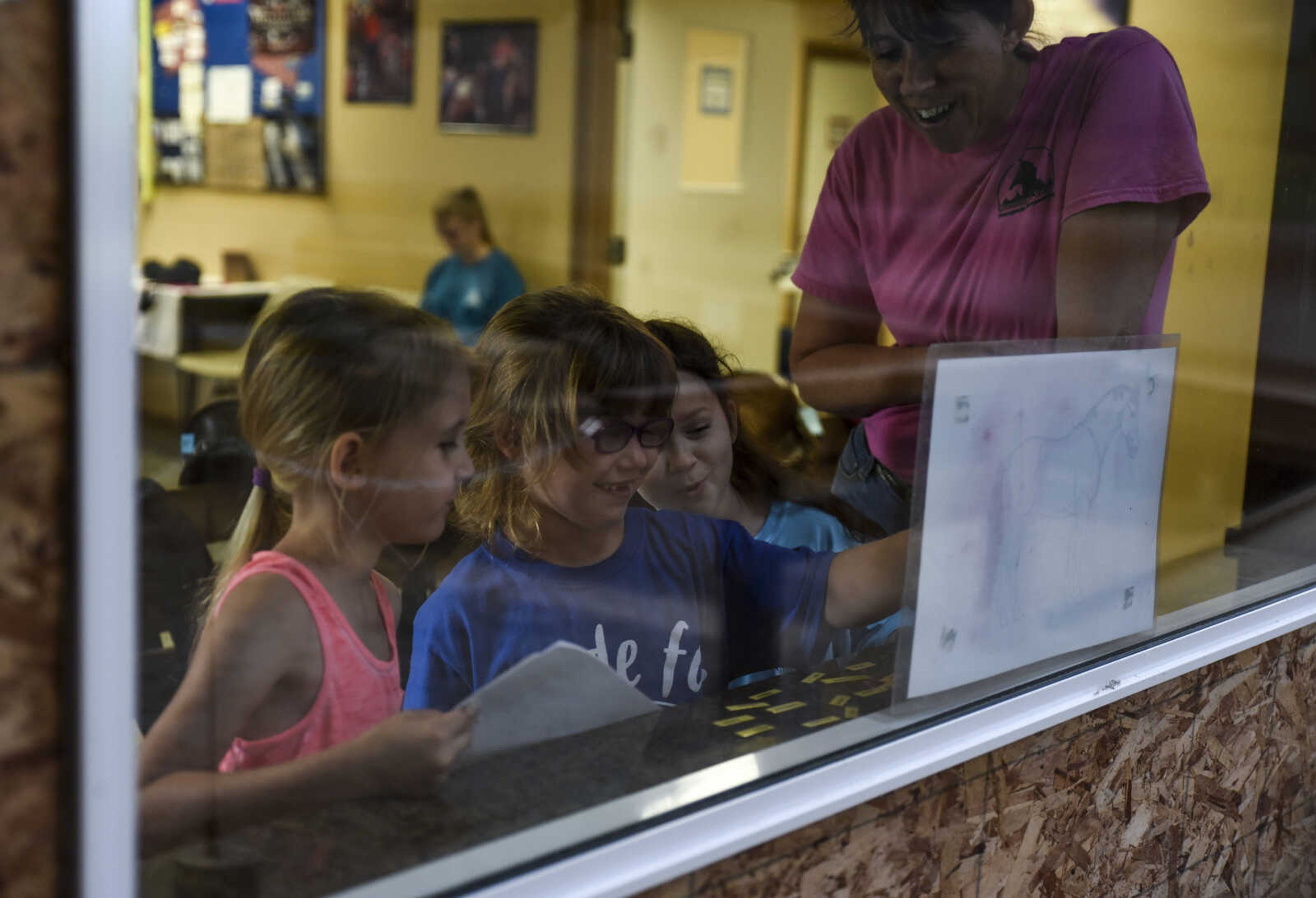 Lindyn Davenport, center, 6, practices labeling parts of a horse with Marie Richardson, left, 5, and Amelia Luttrull, 8, as Varina Luttrull, program director, observes and guides during a summer camp session at Mississippi Valley Therapeutic Horsemanship Friday, June 8, 2018 in Oak Ridge.