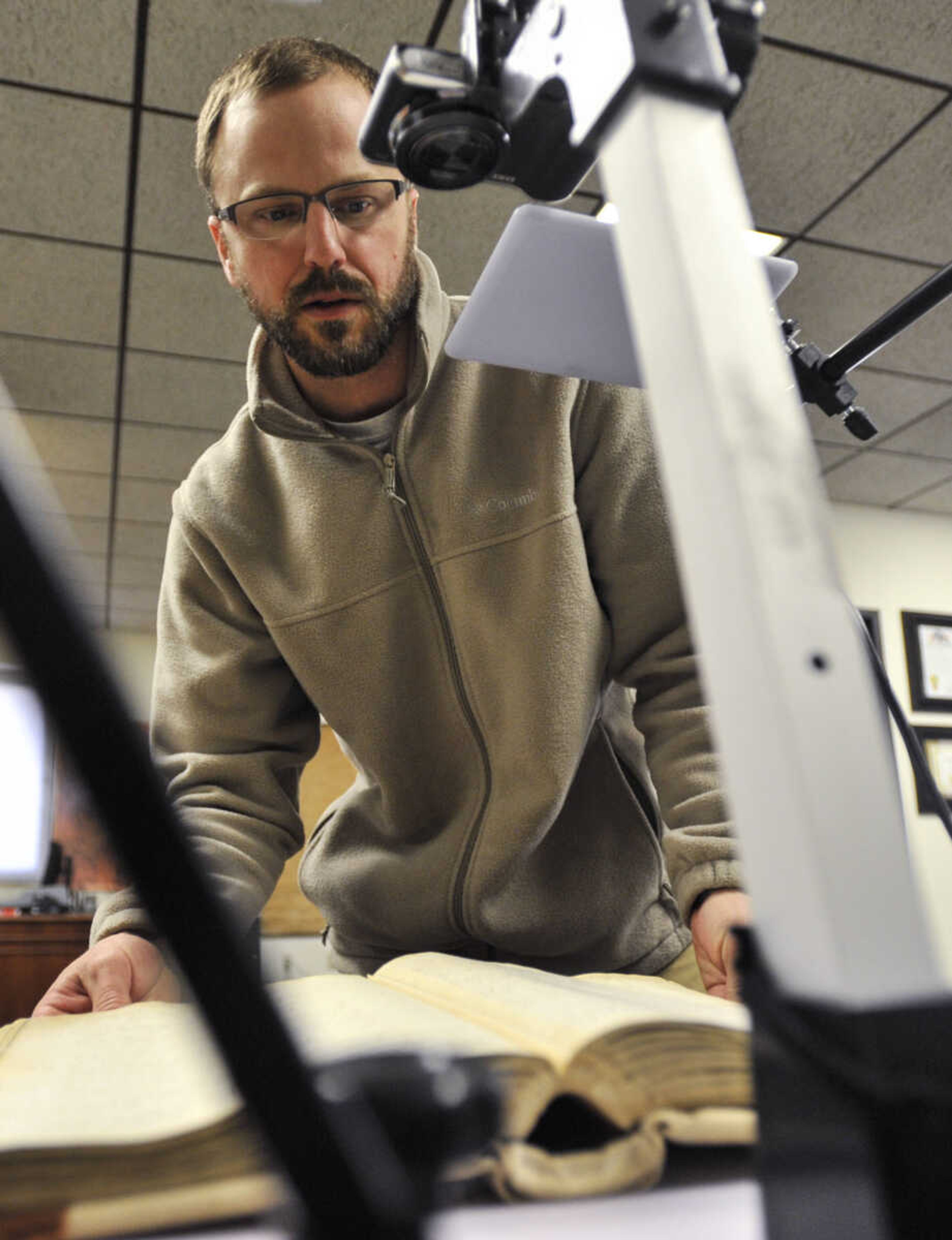 Cape Girardeau County recorder of deeds Andrew Blattner demonstrates how a high-resolution camera and lighted tripod is used to digitize documents in the Recorder's Office on Thursday, March 8, 2018, at the Cape County Administration Building in Jackson.