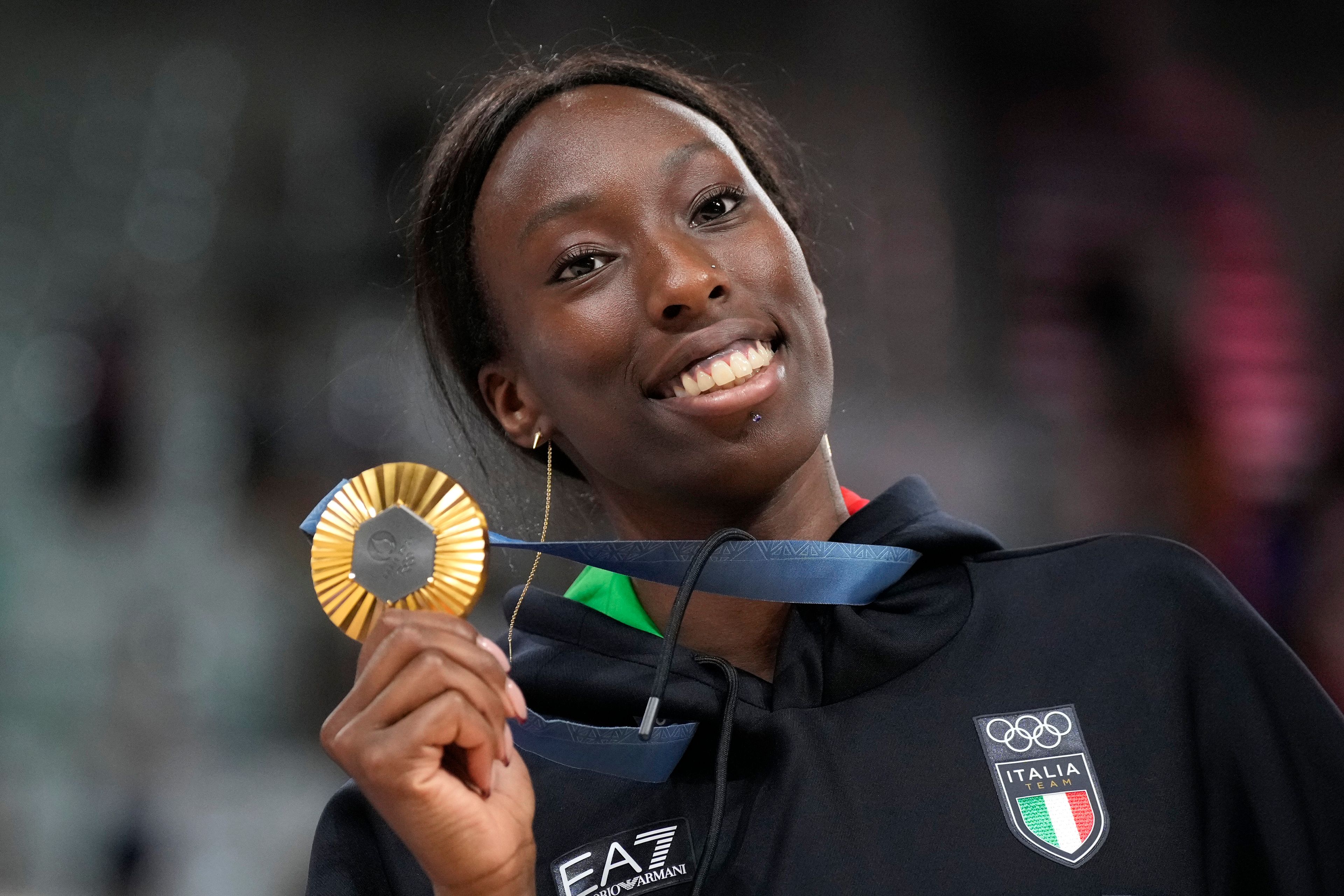 Paola Egonu of Italy shows her gold medal after the medal ceremony at the end of the women's volleyball final match against the United States of America at the 2024 Summer Olympics, Sunday, Aug. 11, 2024, in Paris, France.(AP Photo/Alessandra Tarantino)