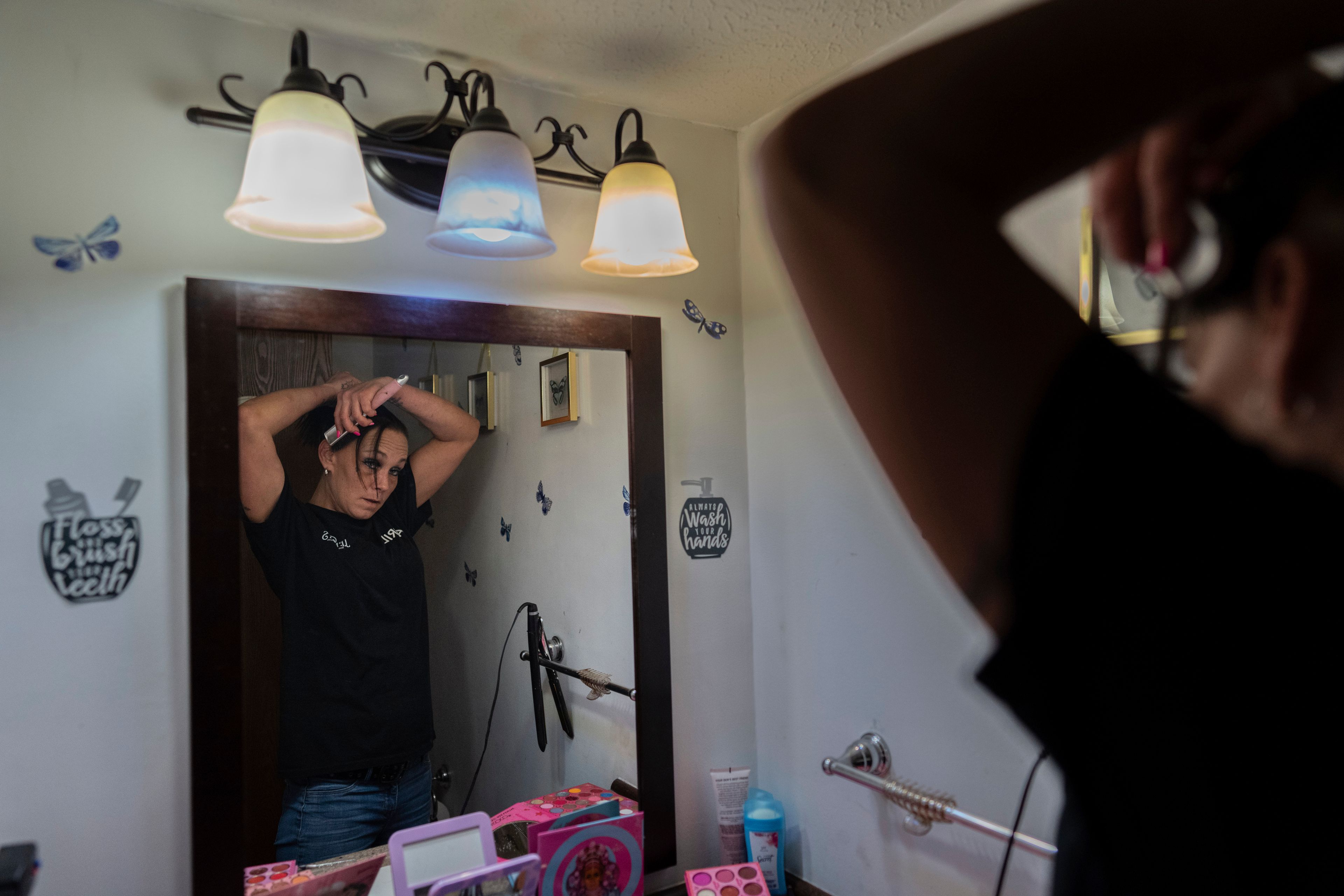 April Youst puts her hair up as she gets ready for work in her West Virginia home on Wednesday, Oct. 9, 2024. (AP Photo/Carolyn Kaster)