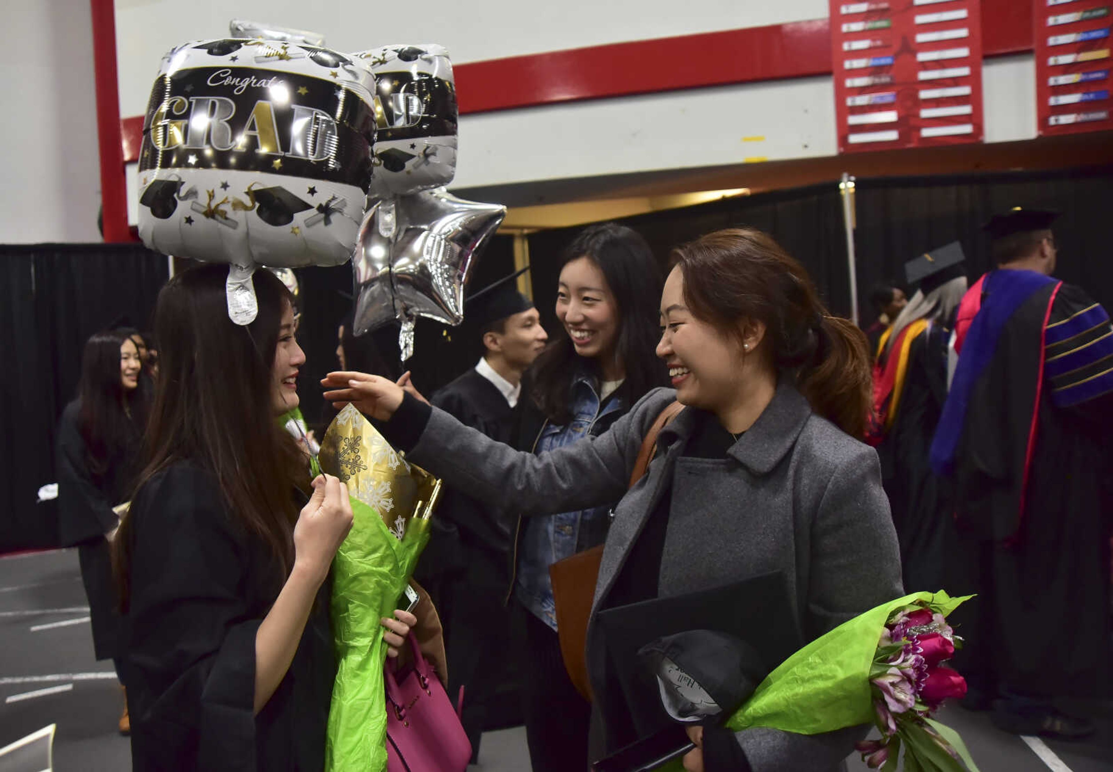 ANDREW J. WHITAKER ~ awhitaker@semissourian.com
Xumeng Zhang, right gives Yifan Yu, left, a hug after Southeast Missouri State University graduation Saturday, Dec. 17, 2016 at the Show Me Center in Cape Girardeau.