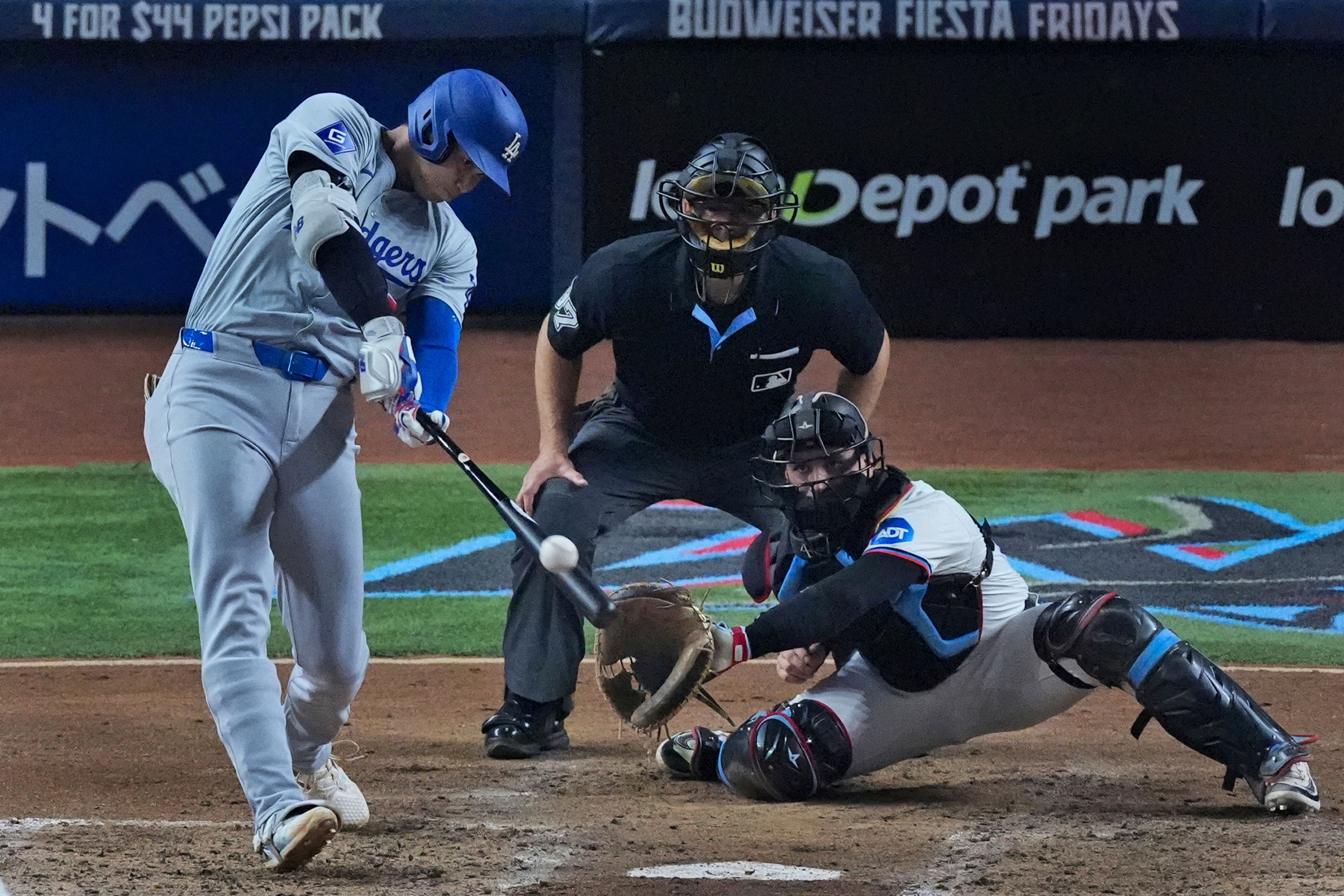 Los Angeles Dodgers' Shohei Ohtani, of Japan, hits a home run scoring Hunter Feduccia during the third inning of a baseball game against the Miami Marlins, Tuesday, Sept. 17, 2024, in Miami. (AP Photo/Wilfredo Lee)