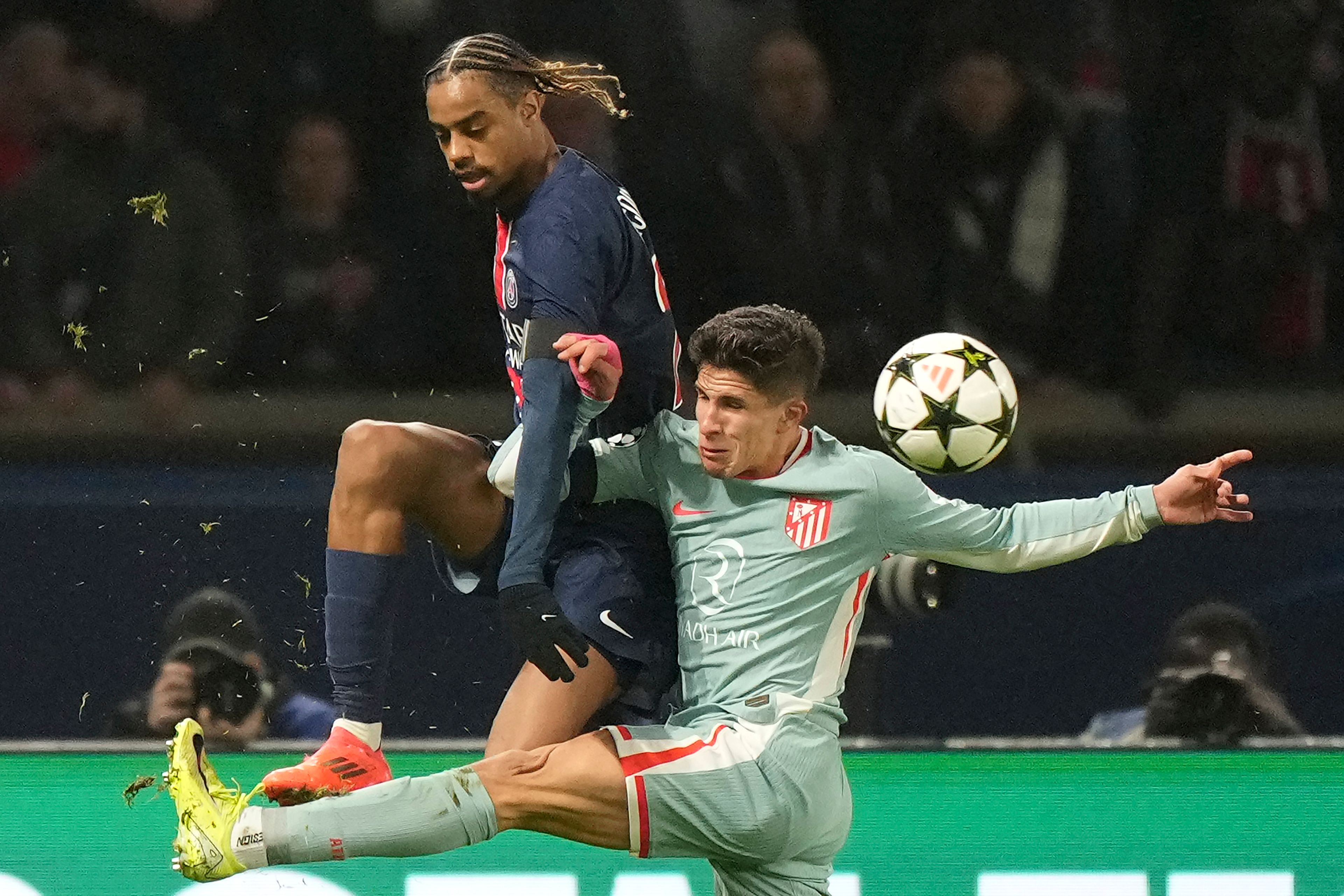 PSG's Bradley Barcola, left, and Atletico Madrid's Giuliano Simeone, right, fight for the ball during the Champions League opening phase soccer match between Paris Saint Germain and Atletico Madrid, at the Parc des Princes stadium, in Paris, Wednesday, Nov. 6, 2024. (AP Photo/Michel Euler)