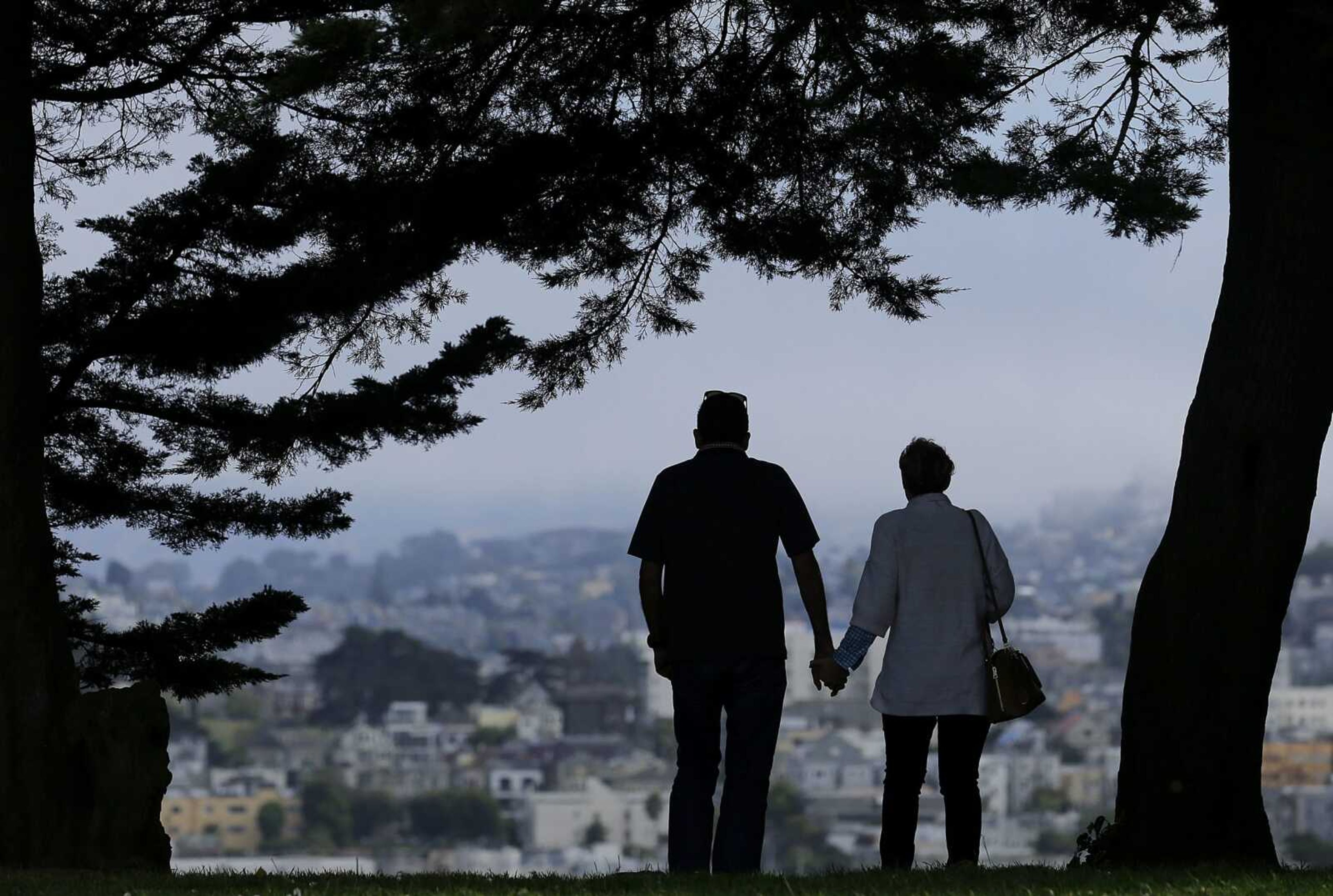 A man and woman walk under trees down a path at Alta Plaza Park in San Francisco. People in the final stretches of their working years feel less prepared to successfully age in their own homes than those who are 65 and older and already likely to have shifted into their retirement years. That age gap is among the key findings of The Associated Press-NORC Center for Public Affairs poll.