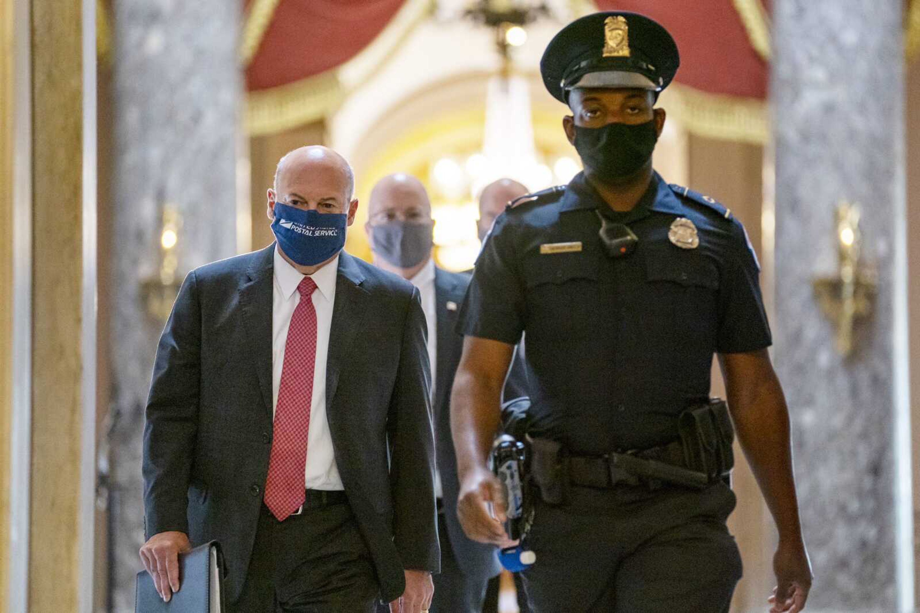 Postmaster General Louis DeJoy, left, is escorted Wednesday to House Speaker Nancy Pelosi's office on Capitol Hill in Washington.