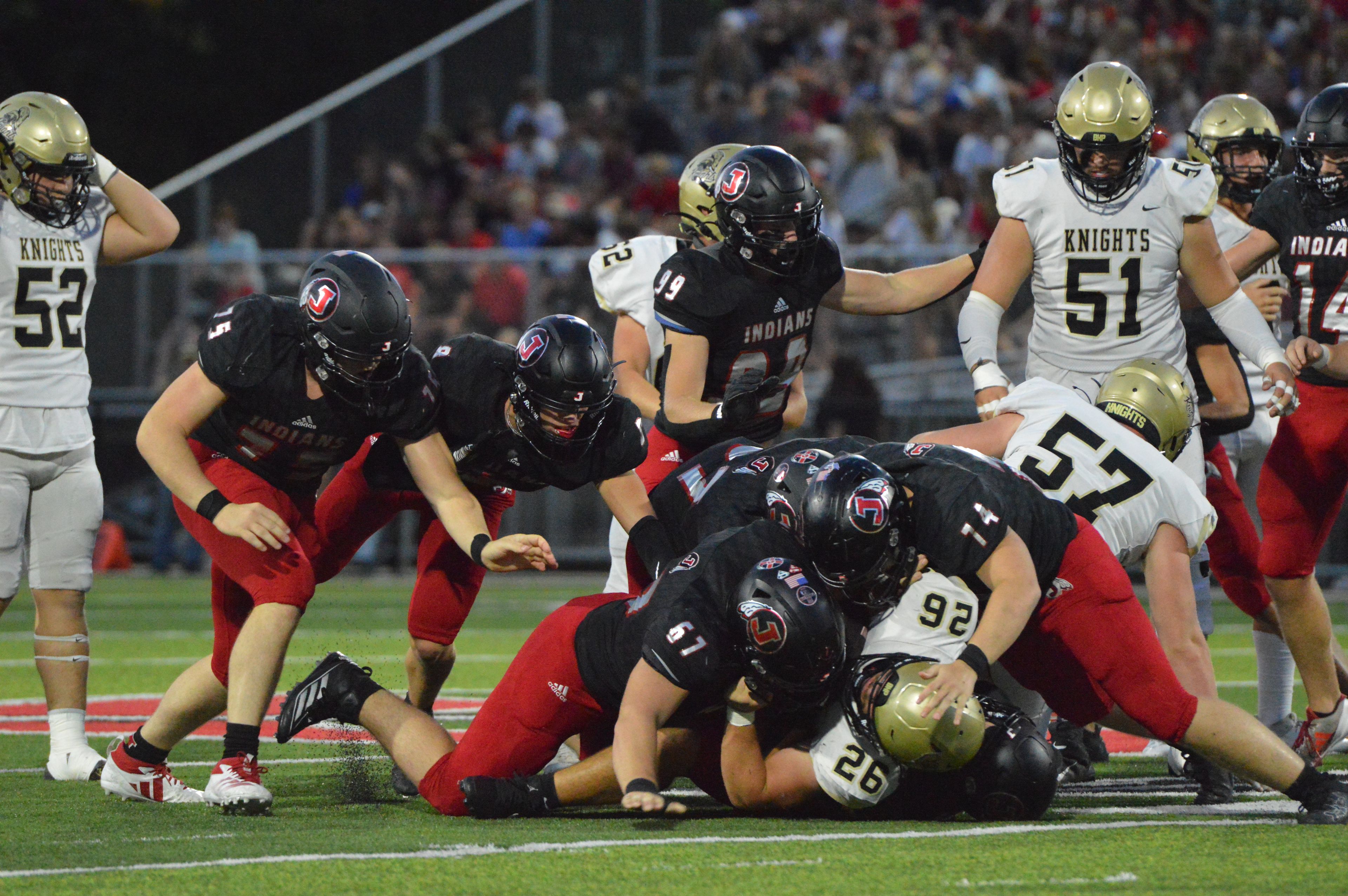 The Jackson defense smothers the Farmington ball carrier on Friday, Sept. 20.