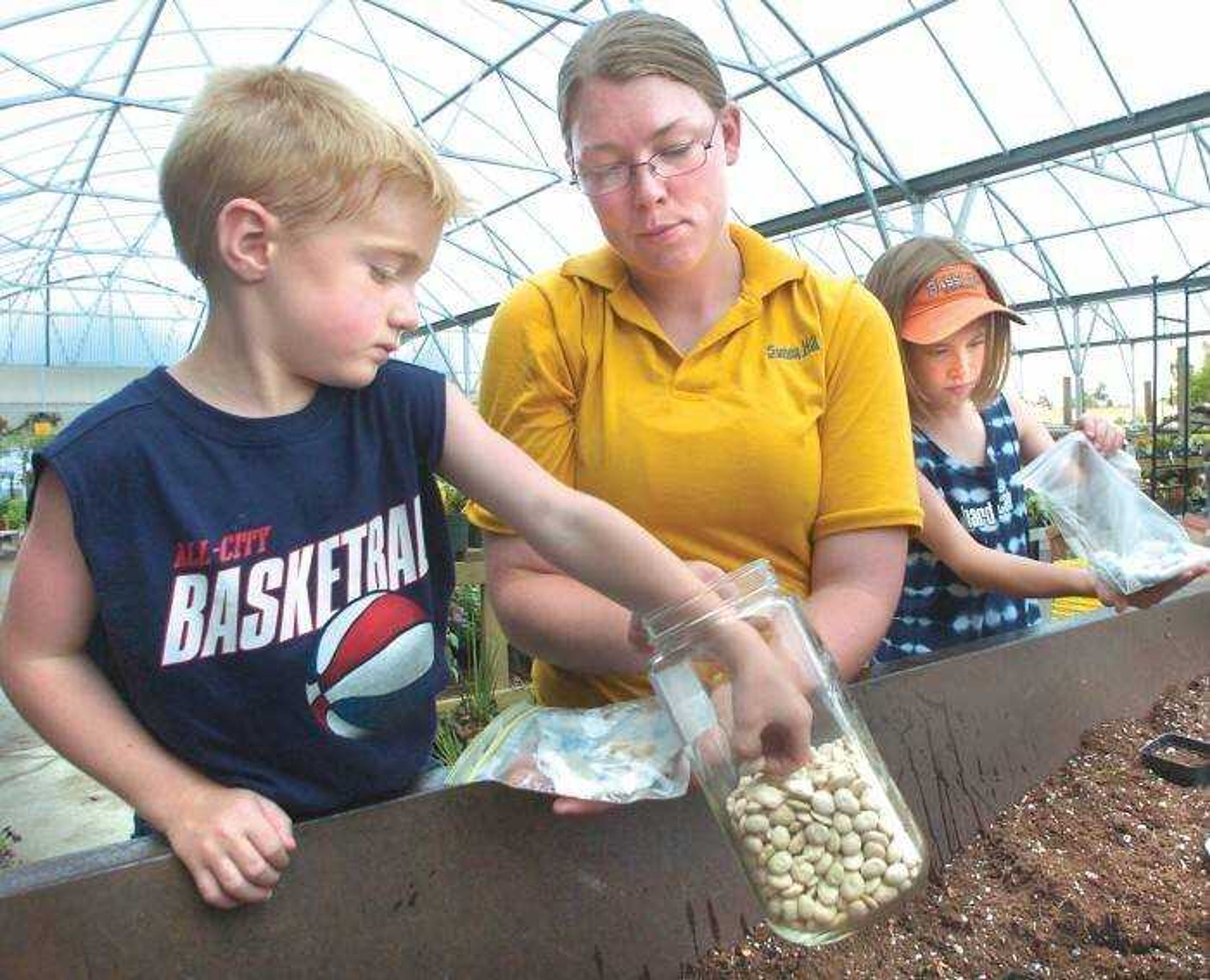 Leah Schnare showed Coby Siebert, 5, left, and Kelsi Siebert, 10, how to prepare lima beans for sprouting in a plastic bag. Children can watch what's happening in the bag while waiting for other beans planted in a pot to grow out. (Fred Lynch)