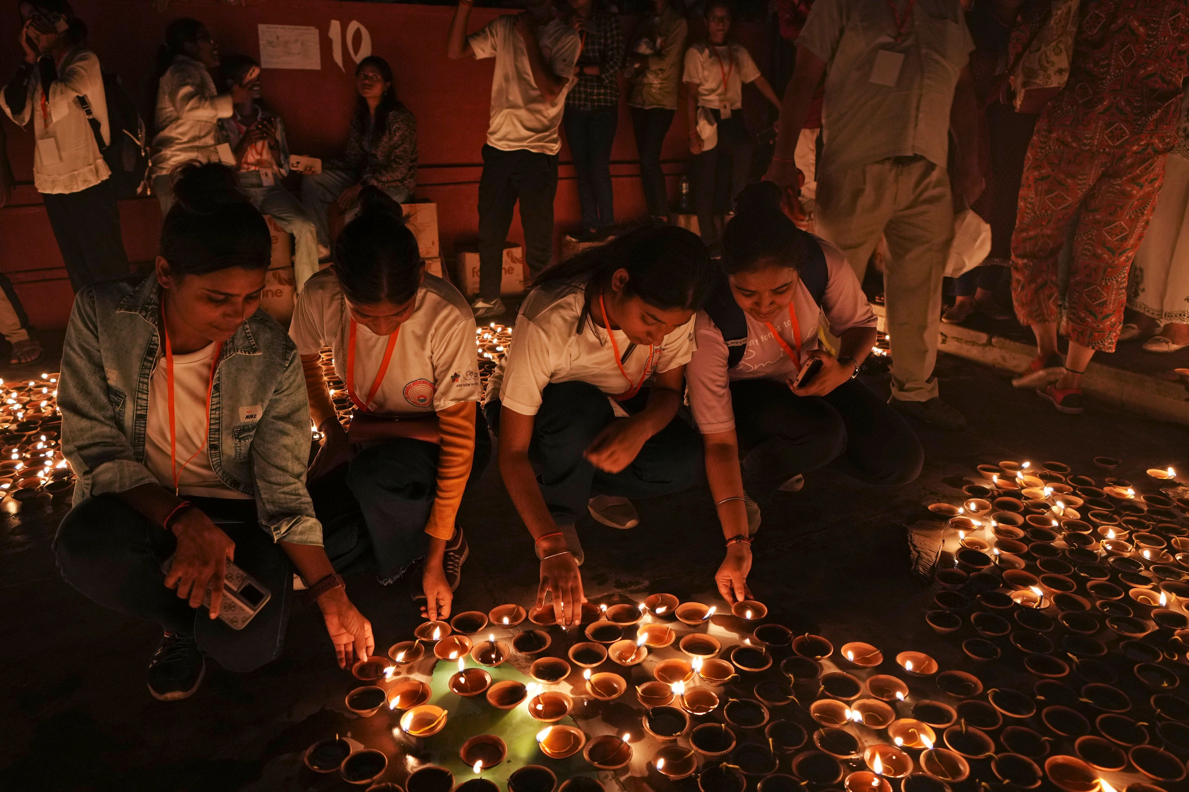 Volunteers light earthen oil lamps along the Saryu river during Deepotsav celebrations on the eve of Diwali, in Ayodhya, India, Wednesday, Oct. 30, 2024. (AP Photo/Rajesh Kumar Singh)