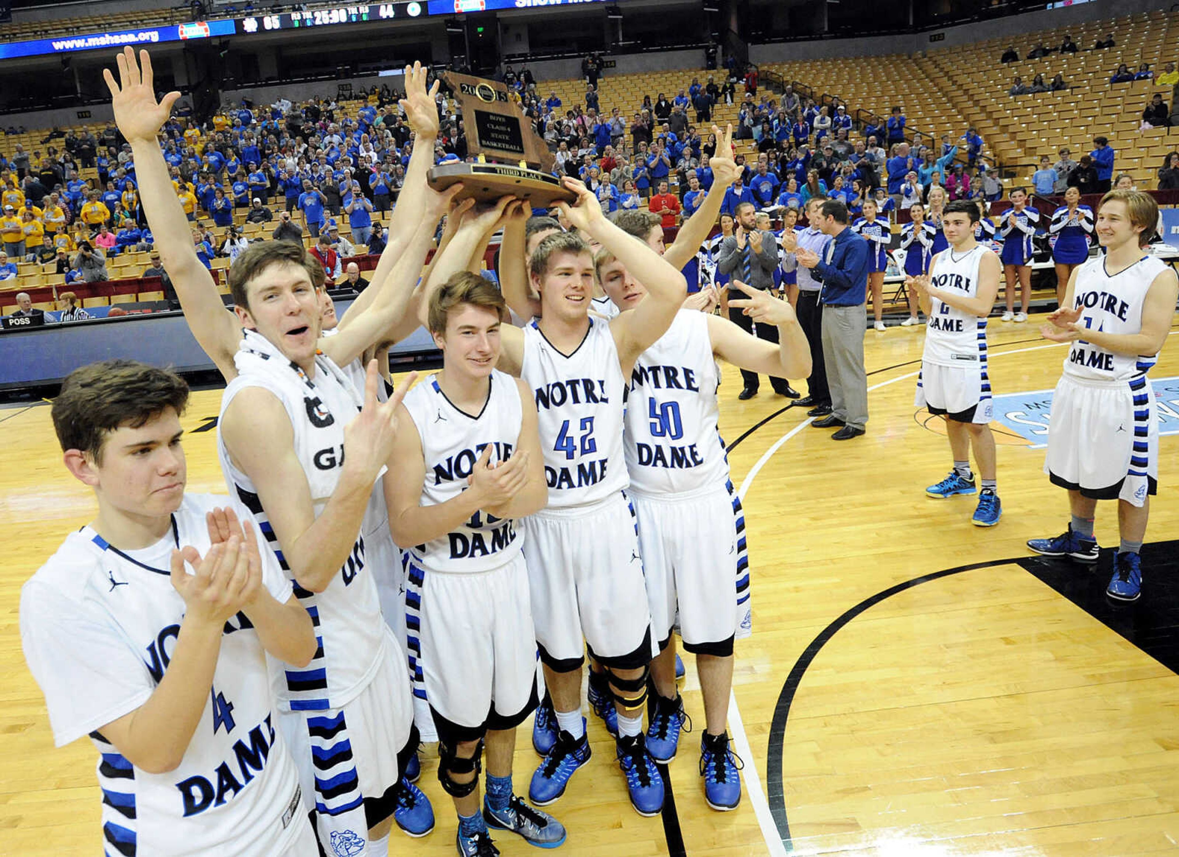 Notre Dame players hold up their Class 4 third place trophy after defeating Bolivar 65-44, Friday, March 20, 2015, in Columbia, Missouri. (Laura Simon)