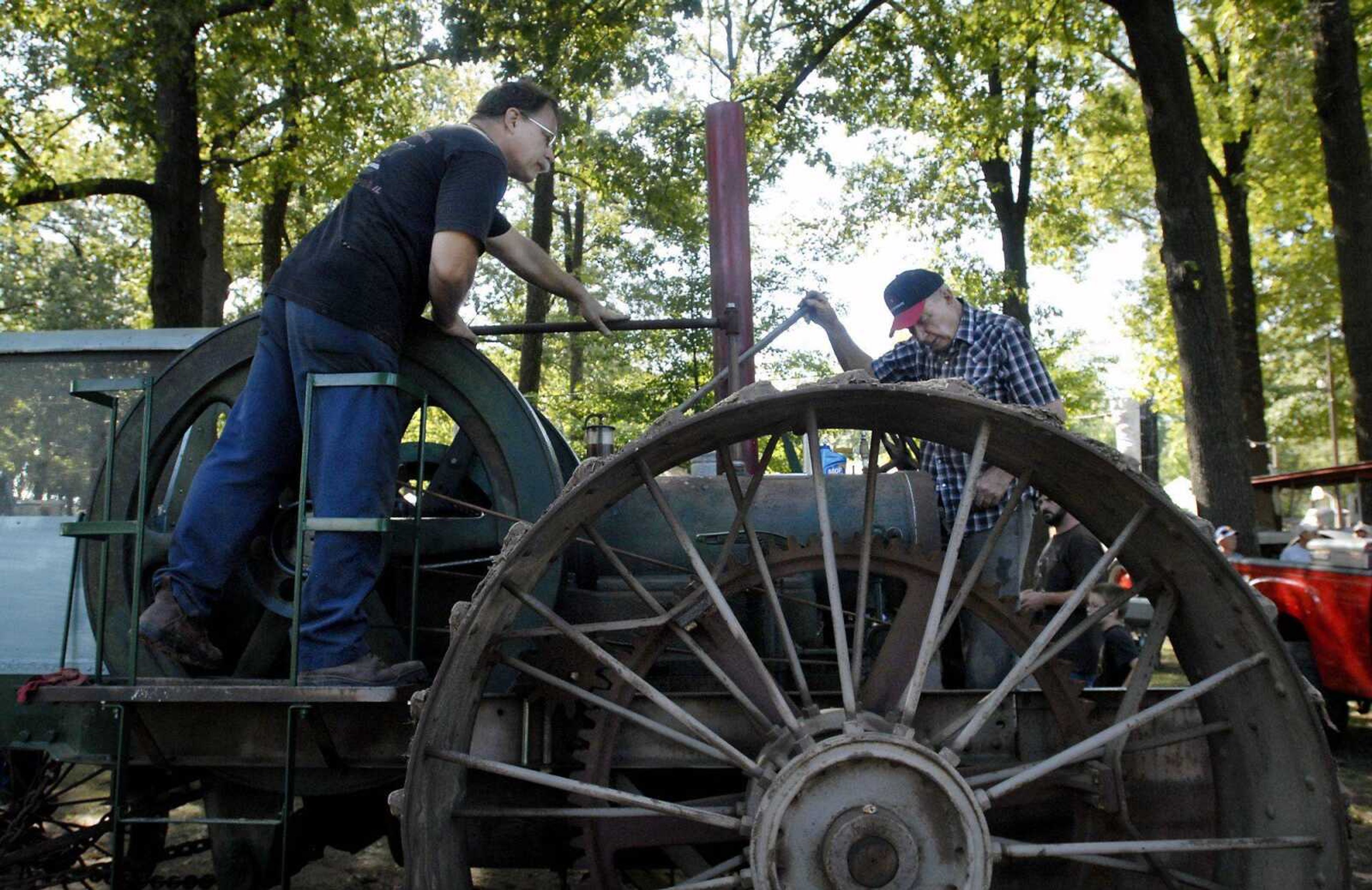 John Hall Jr., left, and John Hall Sr. work on fixing the fuel pump on their 1912 Fairbanks Morse tractor at the SEMO District Fair on Saturday at Arena Park in Cape Girardeau. (Kristin Eberts)