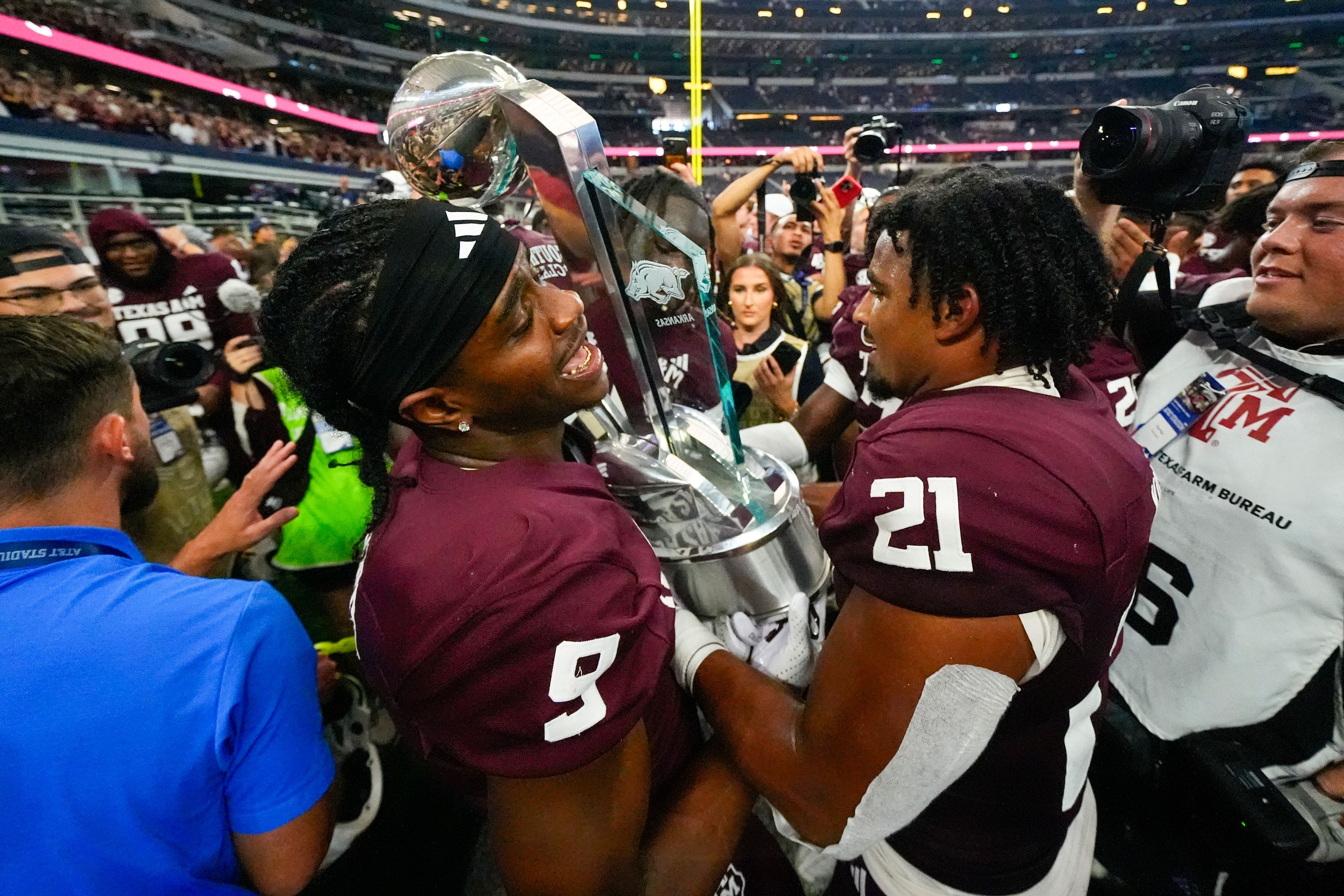 Texas A&M wide receiver Jahdae Walker, left, and Taurean York hols the Southwest Classic trophy after an NCAA college football game against Arkansas, Saturday, Sept. 28, 2024, in Arlington, Texas. Texas A&M won 21-17. (AP Photo/Julio Cortez)