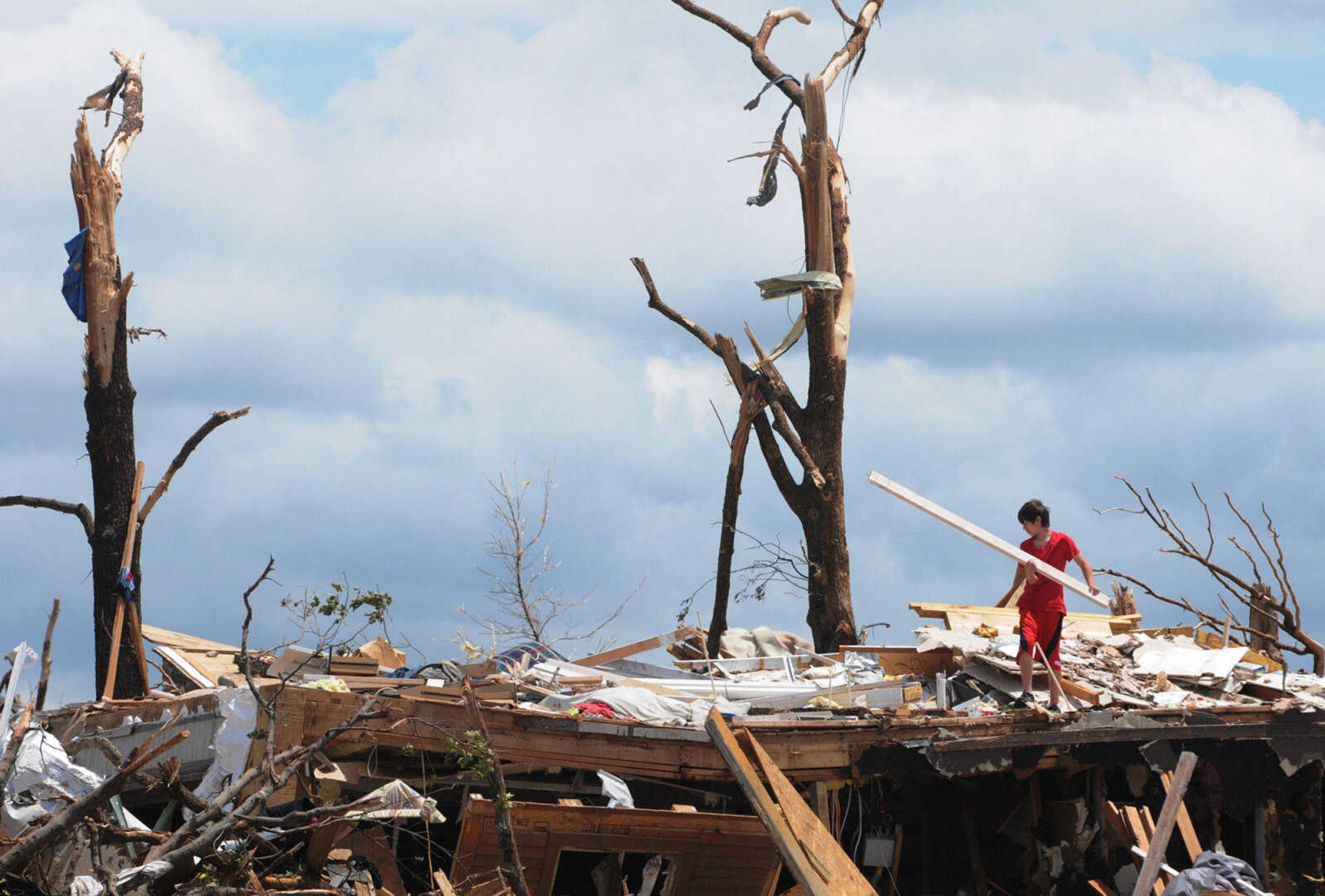 Colin Rush, 14, helps his family salvage items from their home that was destroyed by tornado on Sunday in Joplin, Mo., Wednesday, May 25, 2011. (AP Photo/Mike Gullett)