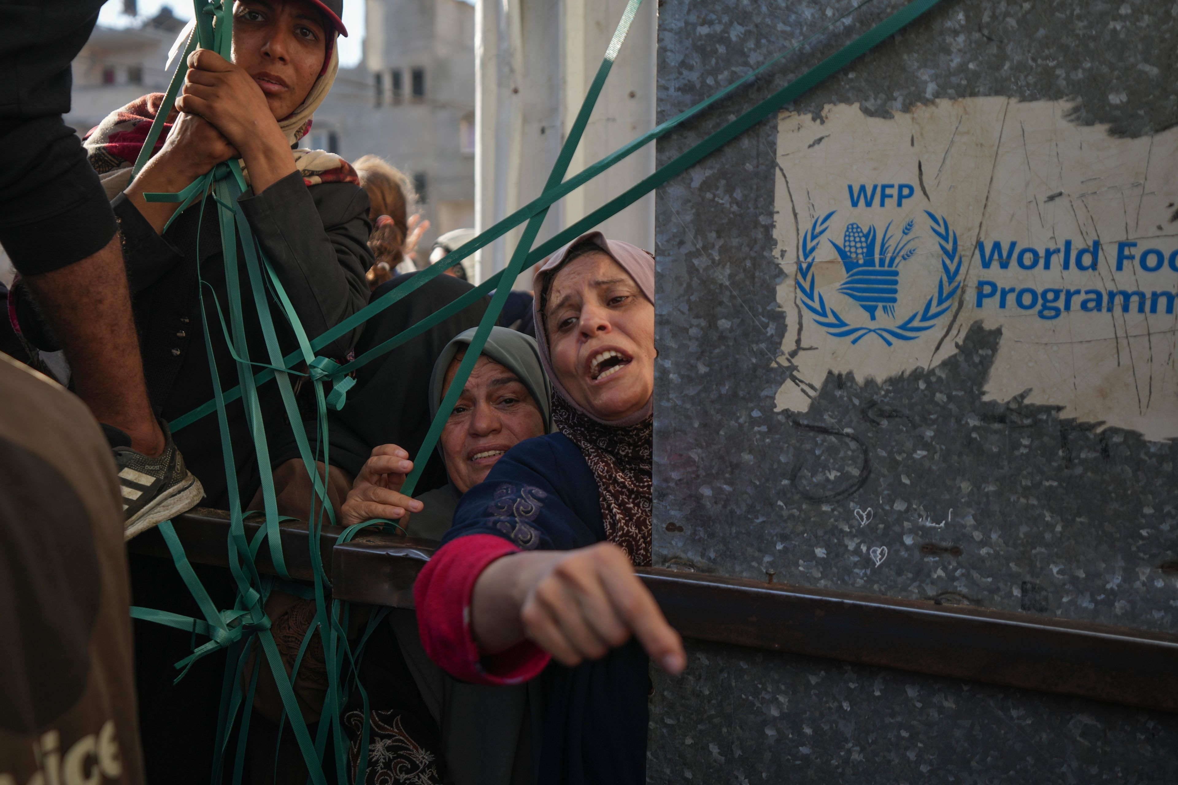 Women line up in front of a bakery to get their share of bread in Deir al-Balah, Gaza Strip, Thursday Nov. 21, 2024. Some bakeries in the Gaza Strip reopened Thursday morning after shuttering for several days due to a flour shortage and lack of food aid. (AP Photo/Abdel Kareem Hana)