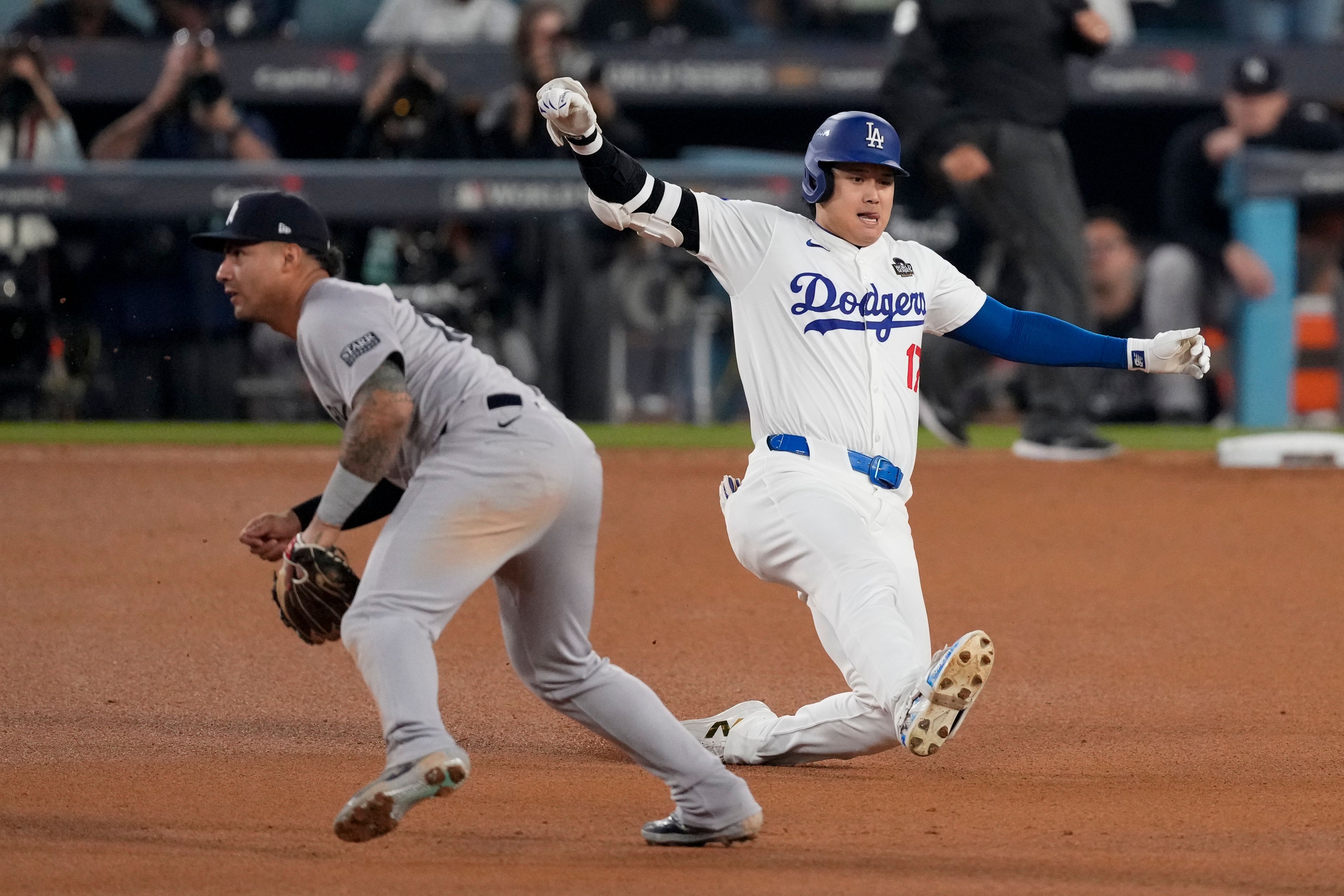 Los Angeles Dodgers' Shohei Ohtani slides into second base for a double past New York Yankees second baseman Gleyber Torres during the eighth inning in Game 1 of the baseball World Series, Friday, Oct. 25, 2024, in Los Angeles. (AP Photo/Mark J. Terrill)