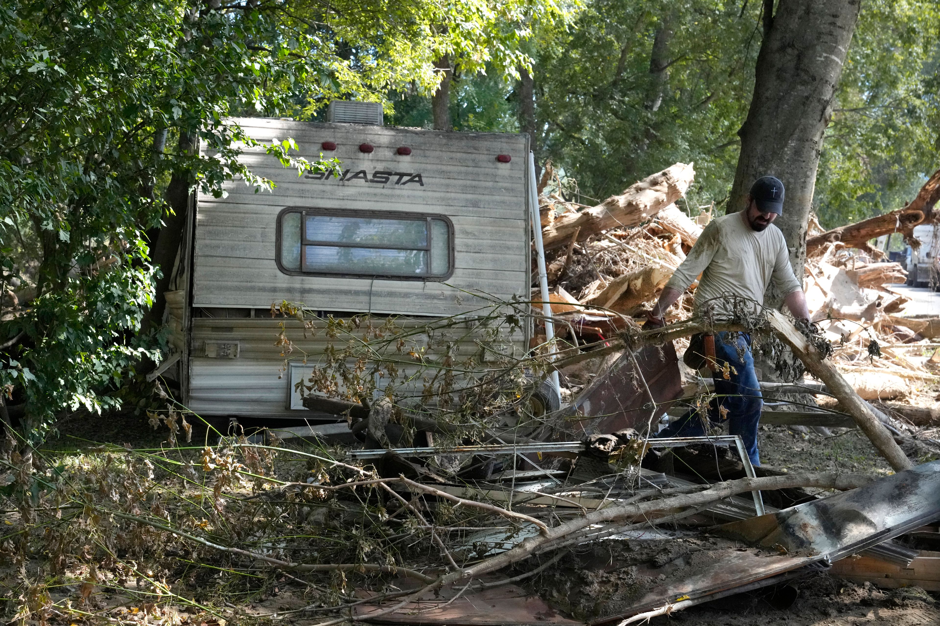 A person clears debris left in the aftermath of Hurricane Helene Saturday, Oct. 5, 2024, in Del Rio, Tenn. (AP Photo/Jeff Roberson)