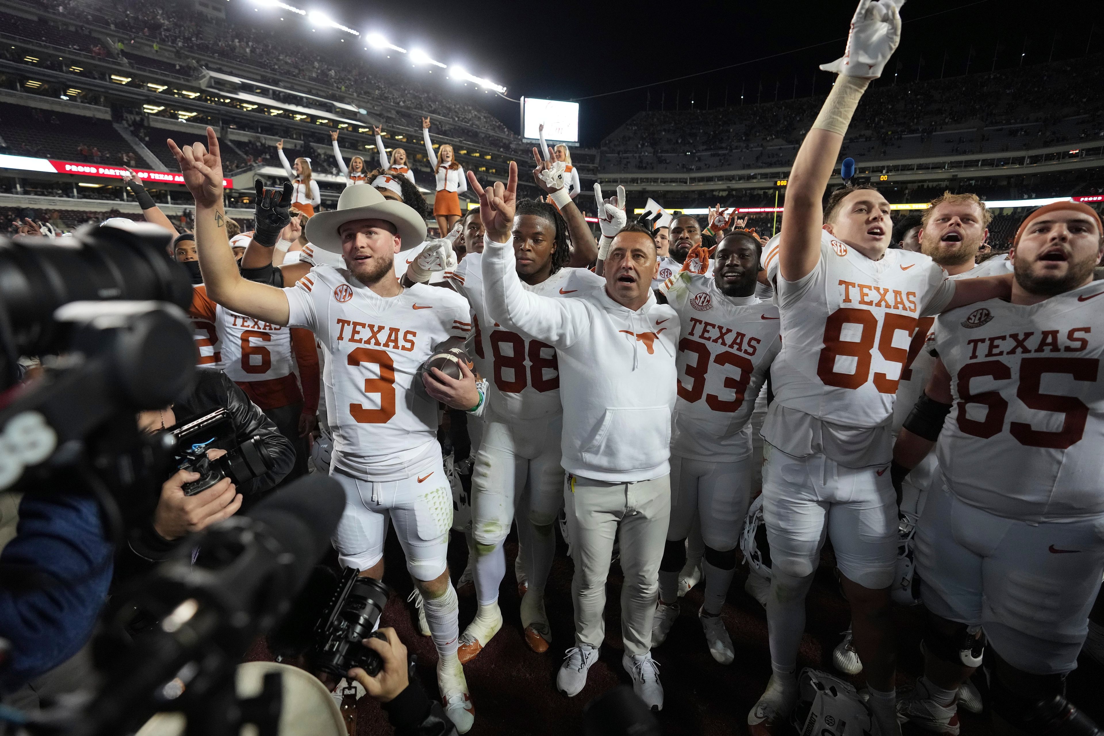 Texas head coach Steve Sarkisian, center, along with quarterback Quinn Ewers, left, and the rest of the Longhorns, after beating Texas A&M in an NCAA college football game, Saturday, Nov. 30, 2024, in College Station, Texas. (AP Photo/Sam Craft)