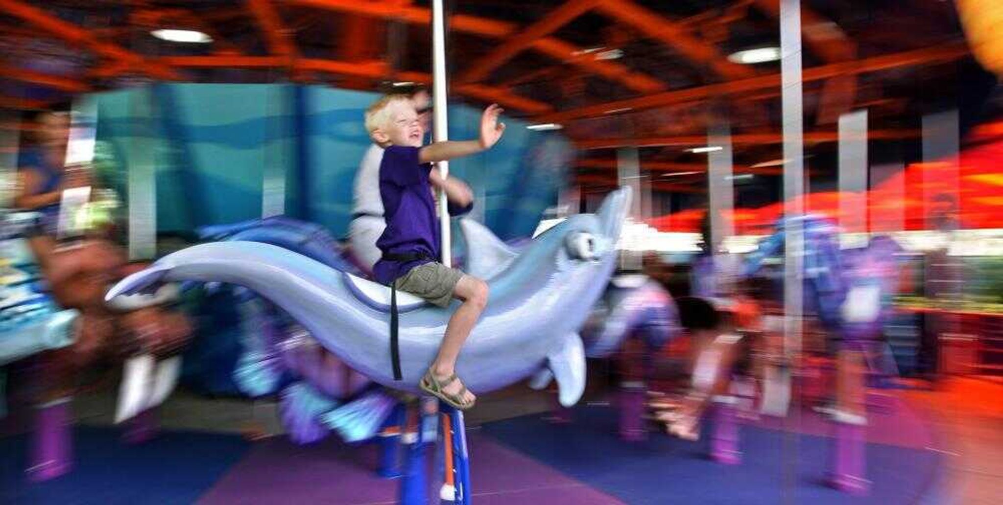 A young guest rode a dolphin on the Sea Carousel at the new Shamu's Happy Harbor at SeaWorld Orlando in Orlando, Fla. The new carousel features 65 sea creatures. The expansion of Happy Harbor includes the addition of three new rides. (JOE BURBANK ~ Orlando Sentinel)