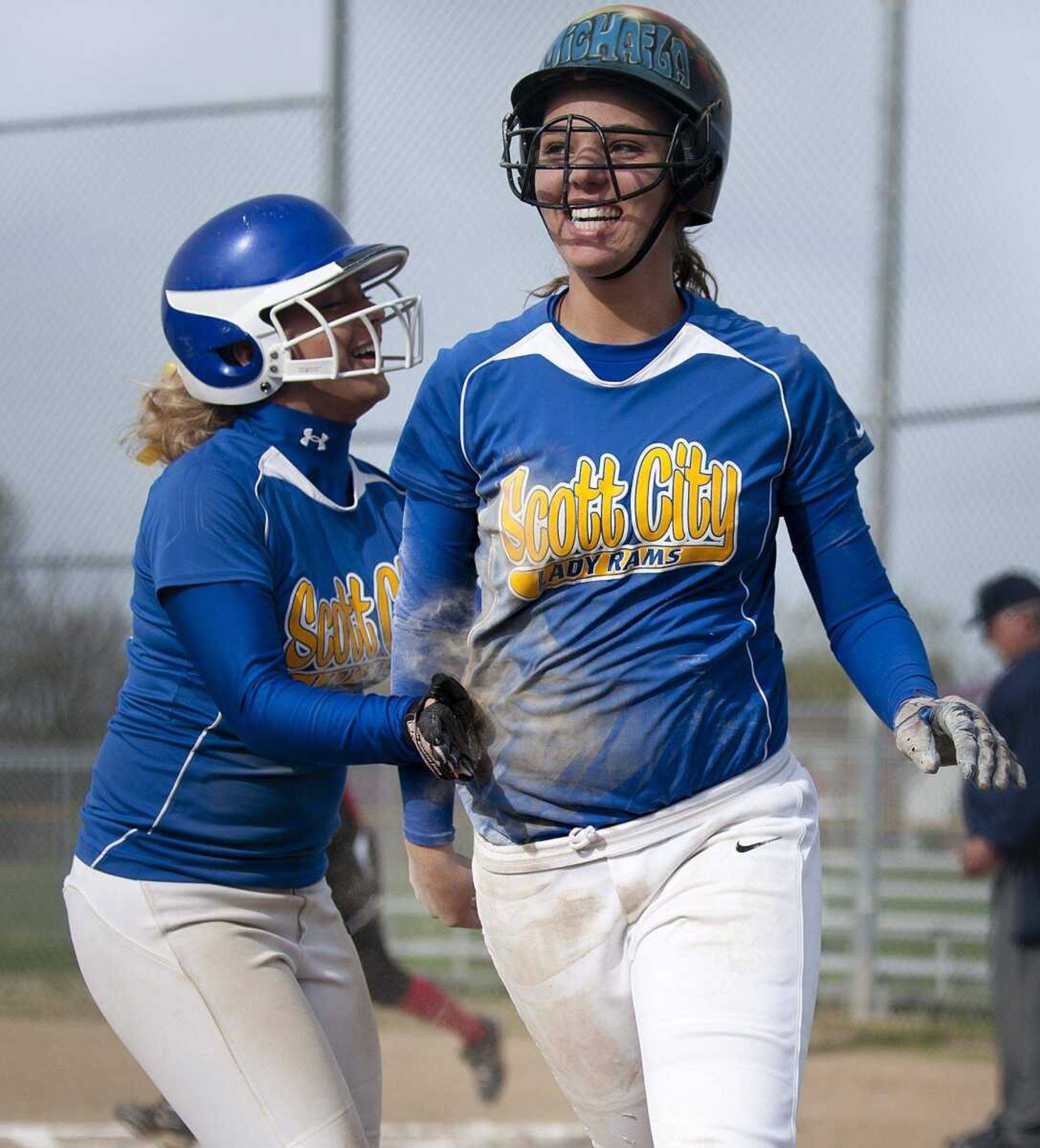 Scott City center fielder Shelby Rhymer, left, congratulates Michaela Kiefer after Kiefer scored in the second inning of the Rams' 18-3 four-inning win over the Woodland Cardinals on Wednesday at Scott City High School. (Adam Vogler)