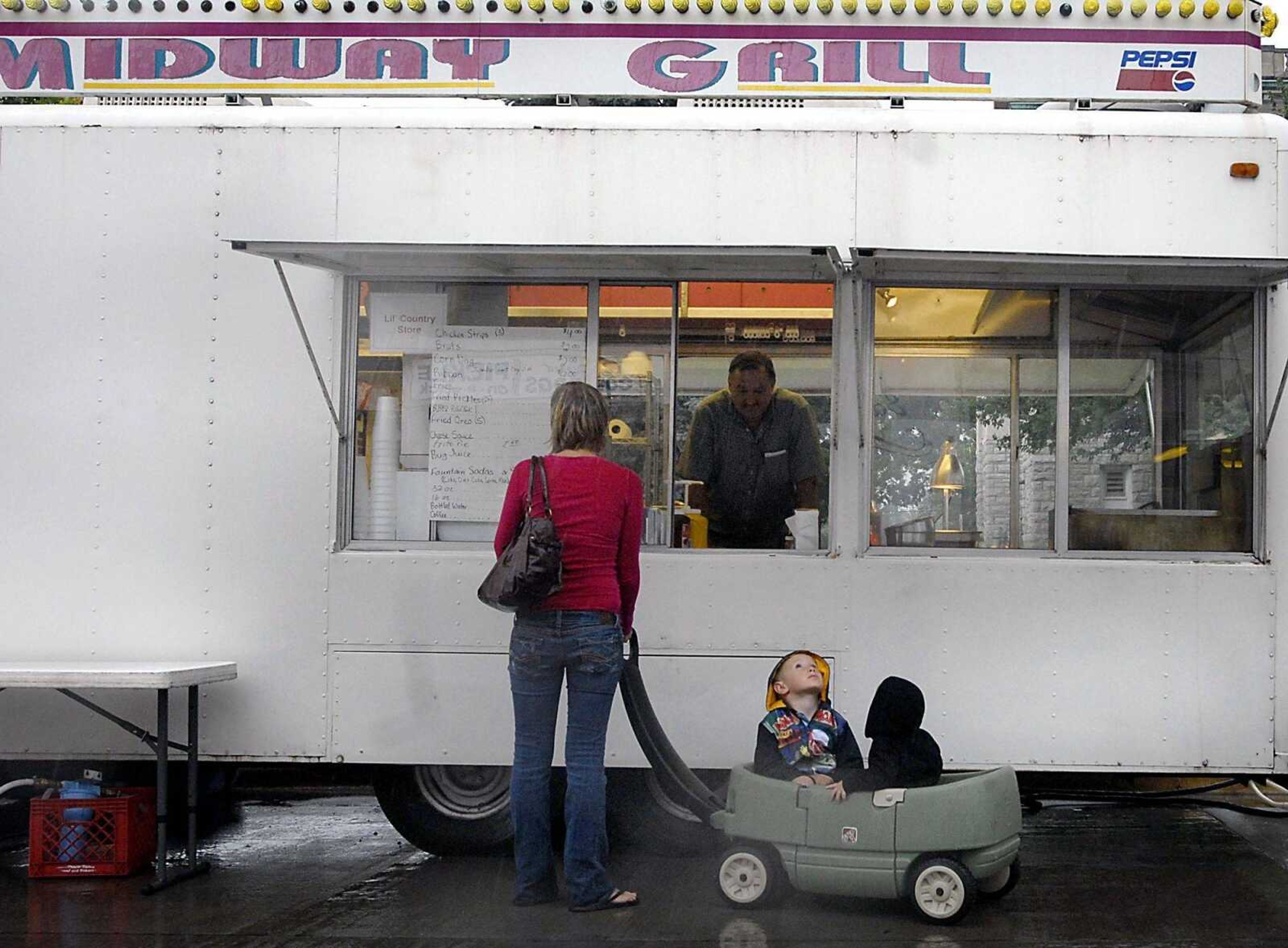 Scott Pikey, 3, looks skyward as his mother Bretton orders food for him and his brother Logan, 16-months, during a rainy visit to Homecomers Tuesday evening, July 21, 2009, in Jackson. (Kit Doyle)