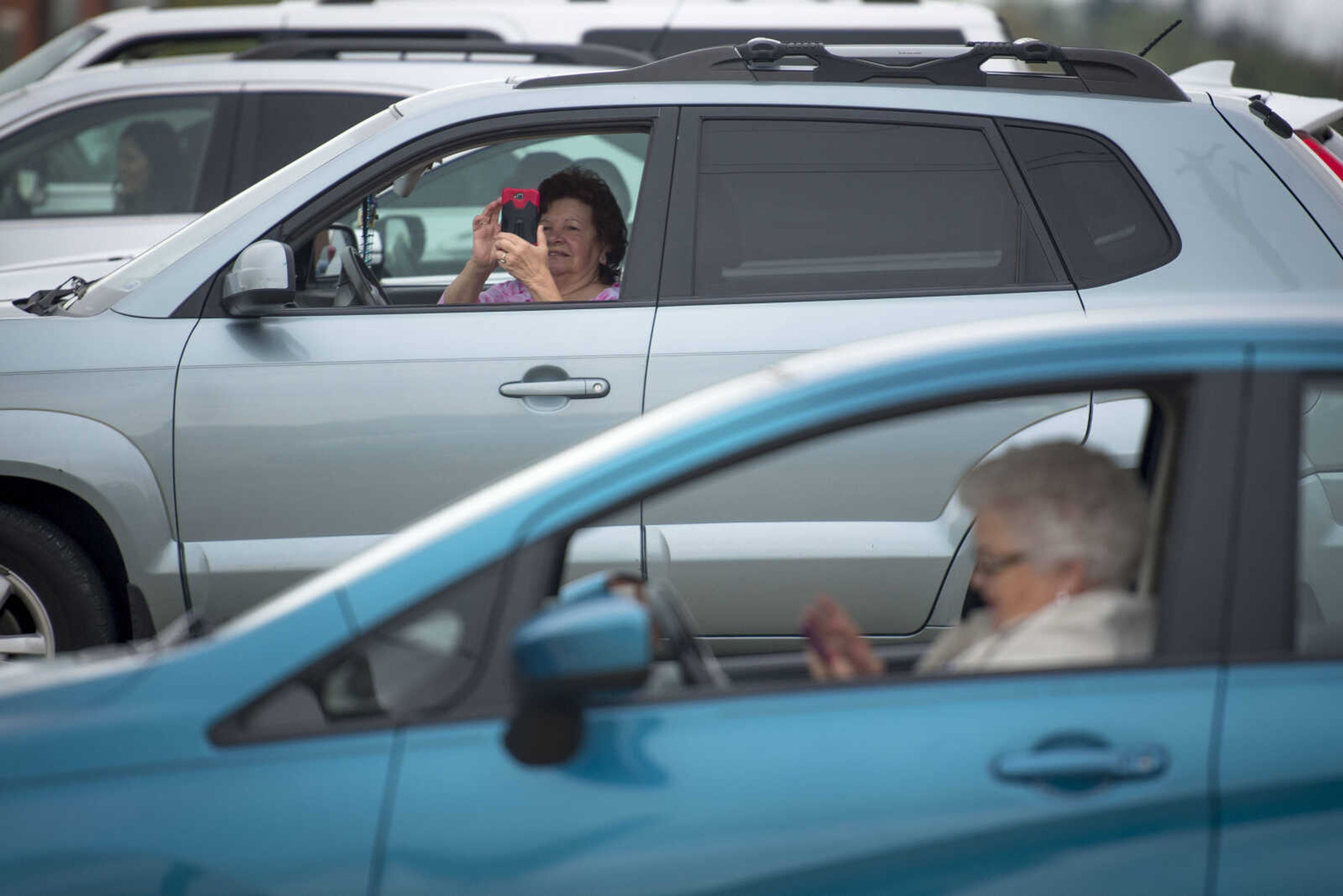 Wanda Choate takes a photo on her phone while parked next to Margaret Tallent, bottom right, as they await the start of First Baptist Jackson's drive-in Easter service Sunday, April 12, 2020, in Jackson.