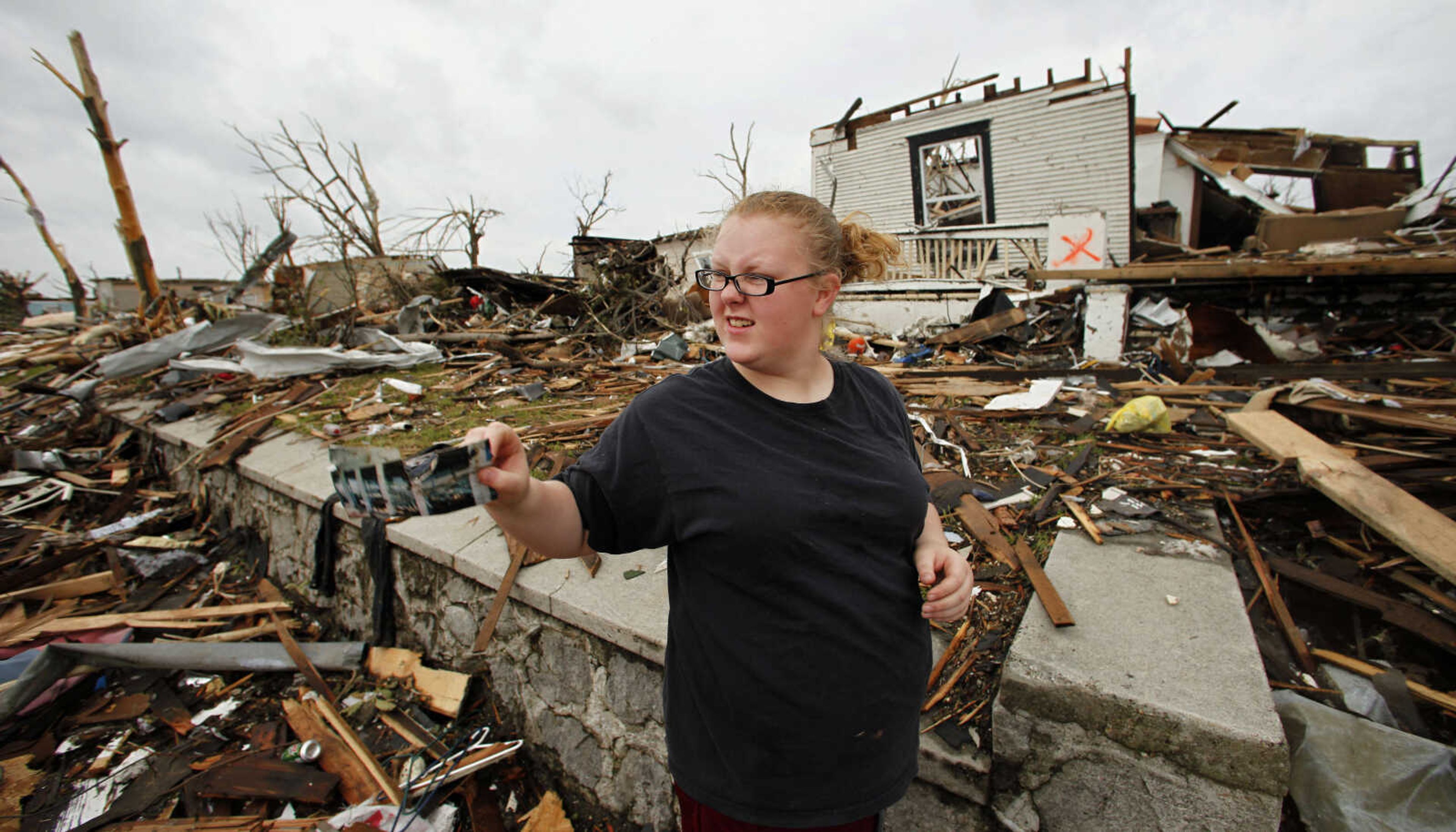 Tera Hall salvages items from a friend's destroyed home in Joplin, Mo. Wednesday, May 25, 2011. An EF-5 tornado tore through much of the city Sunday, damaging a hospital and hundreds of homes and businesses and killing at least 123 people. (AP Photo/Charlie Riedel)