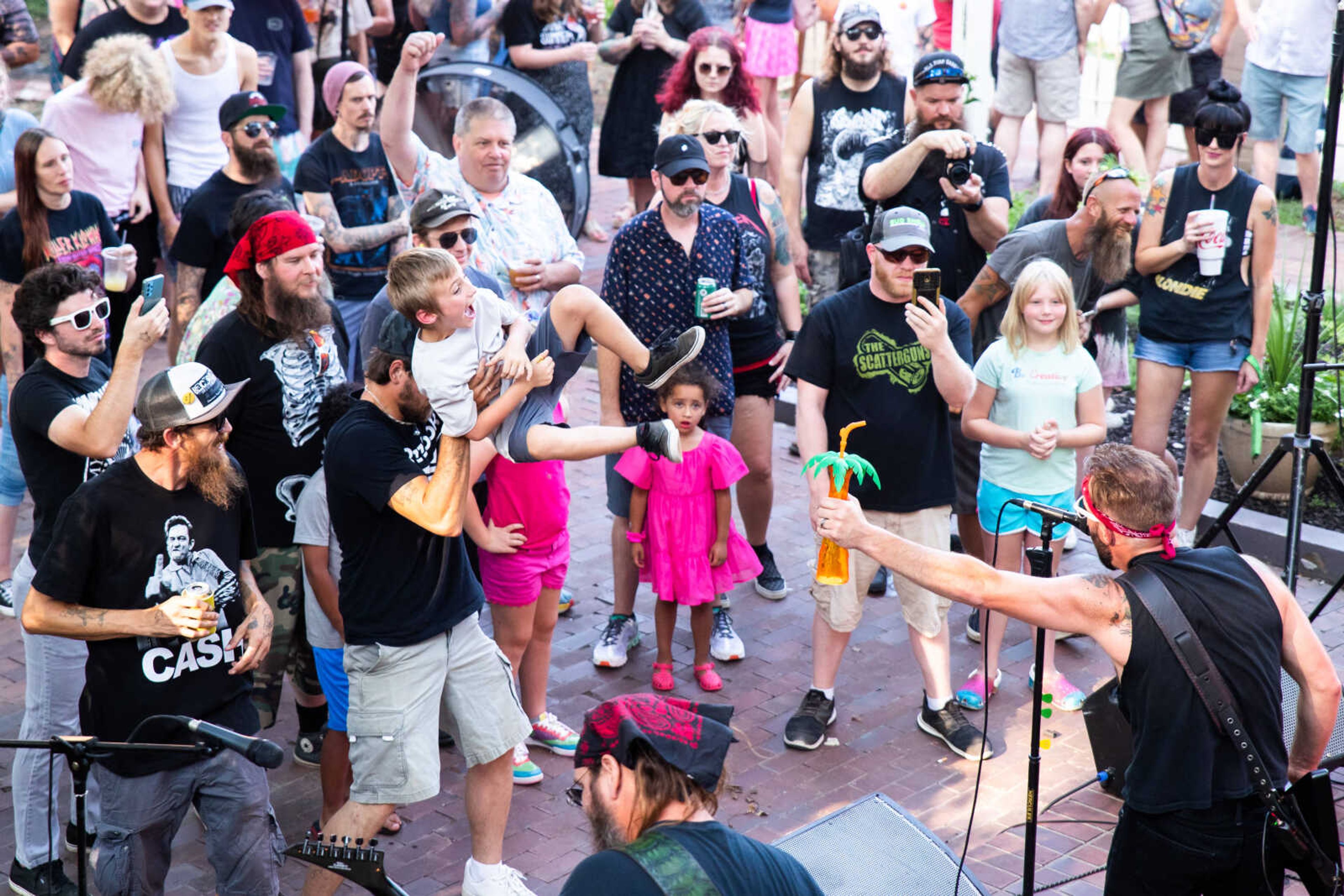 Josh Burns hoists his nephew Dakota Burns, 8, in the air as the band The Scatterguns play during the Summer Slaycation concert&nbsp;on Saturday, July 15 at Ebb &amp; Flow Fermentations.