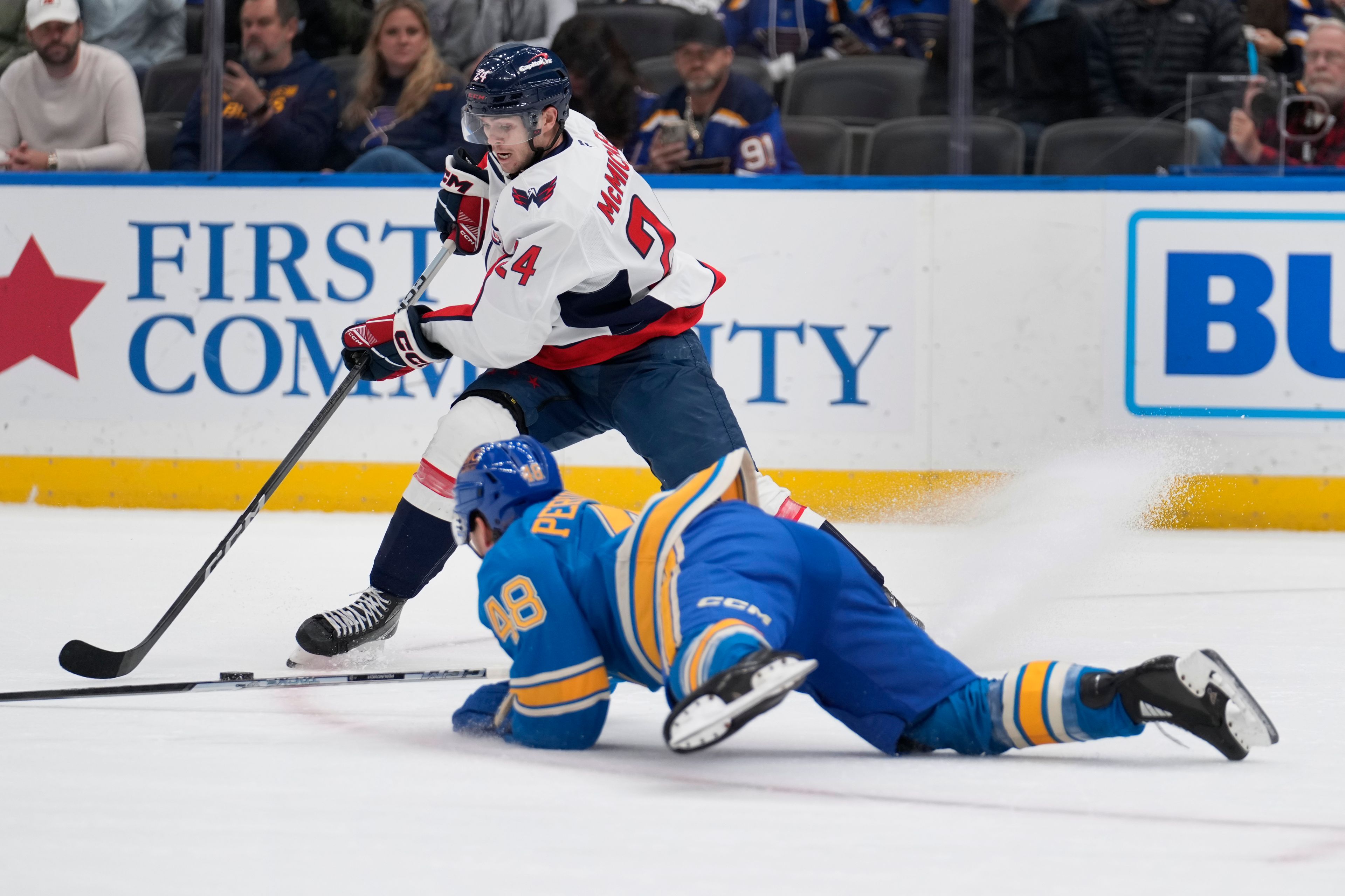 Washington Capitals' Connor McMichael (24) handles the puck as St. Louis Blues' Scott Perunovich (48) defends during the first period of an NHL hockey game Saturday, Nov. 9, 2024, in St. Louis. (AP Photo/Jeff Roberson)