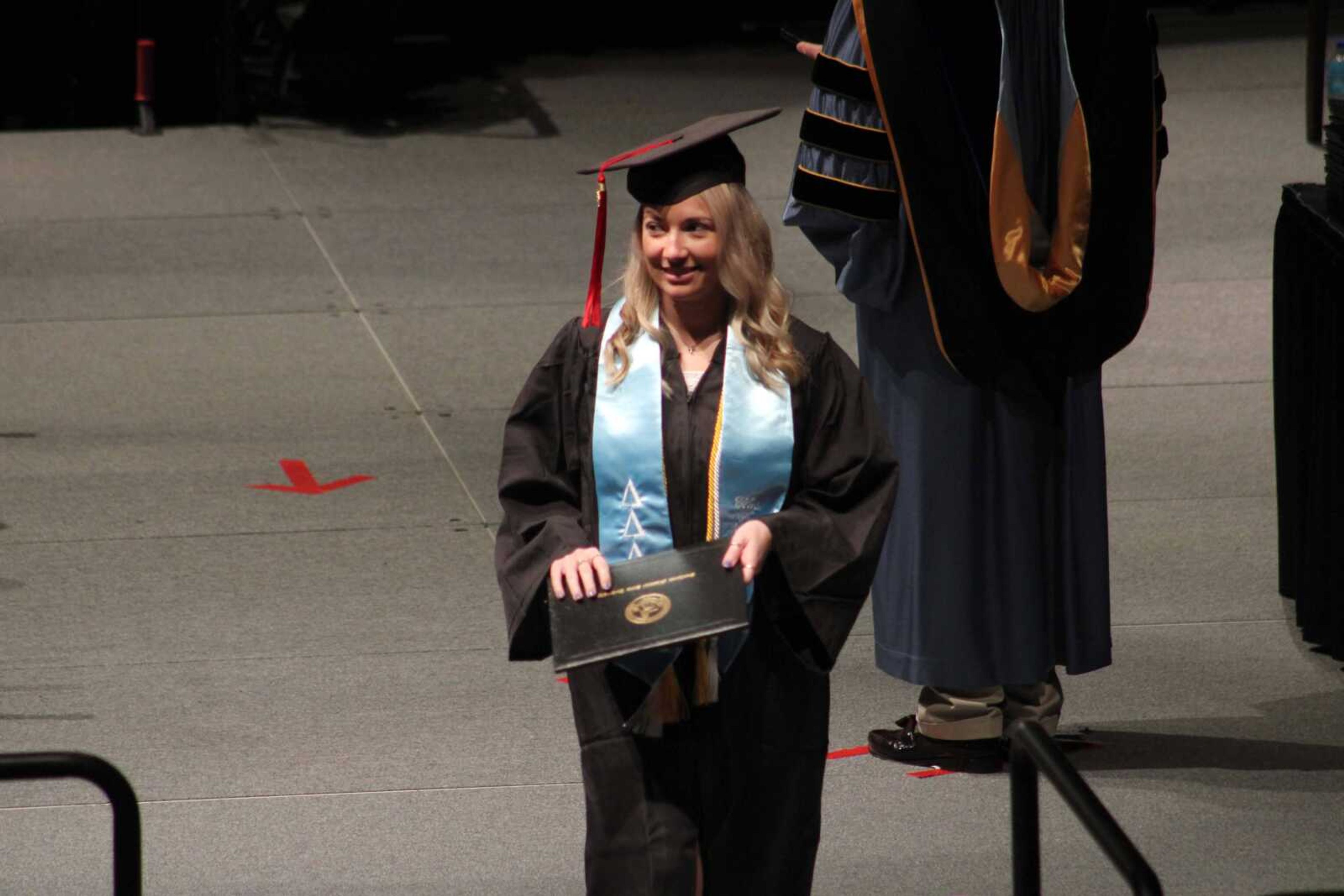 A Southeast Missouri State University graduate looks to the crowd as she walks across the stage during SEMO's afternoon Fall Commencement Ceremony Saturday, Dec. 18, 2021, at the Show Me Center in Cape Girardeau.