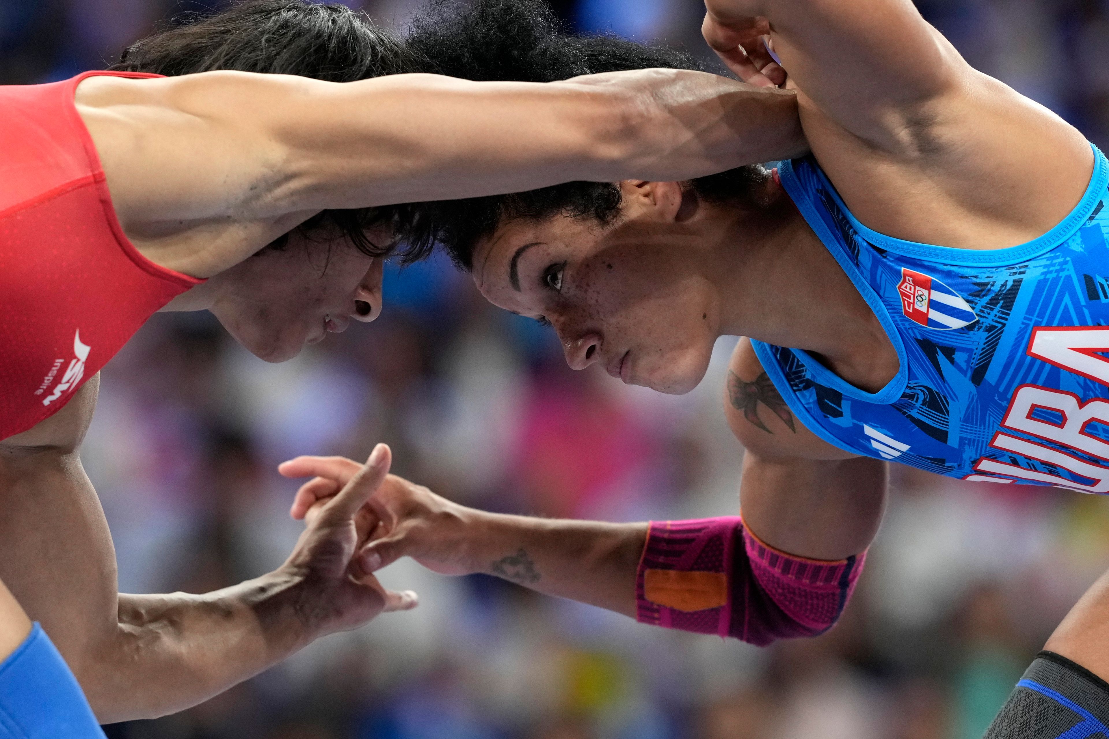 CORRECTS NAME TO VINESH PHOGAT, NOT VINESH VINESH - India's Vinesh Phogat and Cuba's Yusneylys Guzman, right, compete during their women's freestyle 50kg wrestling semifinal match, at Champ-de-Mars Arena, during the 2024 Summer Olympics, Tuesday, Aug. 6, 2024, in Paris, France. (AP Photo/Eugene Hoshiko)