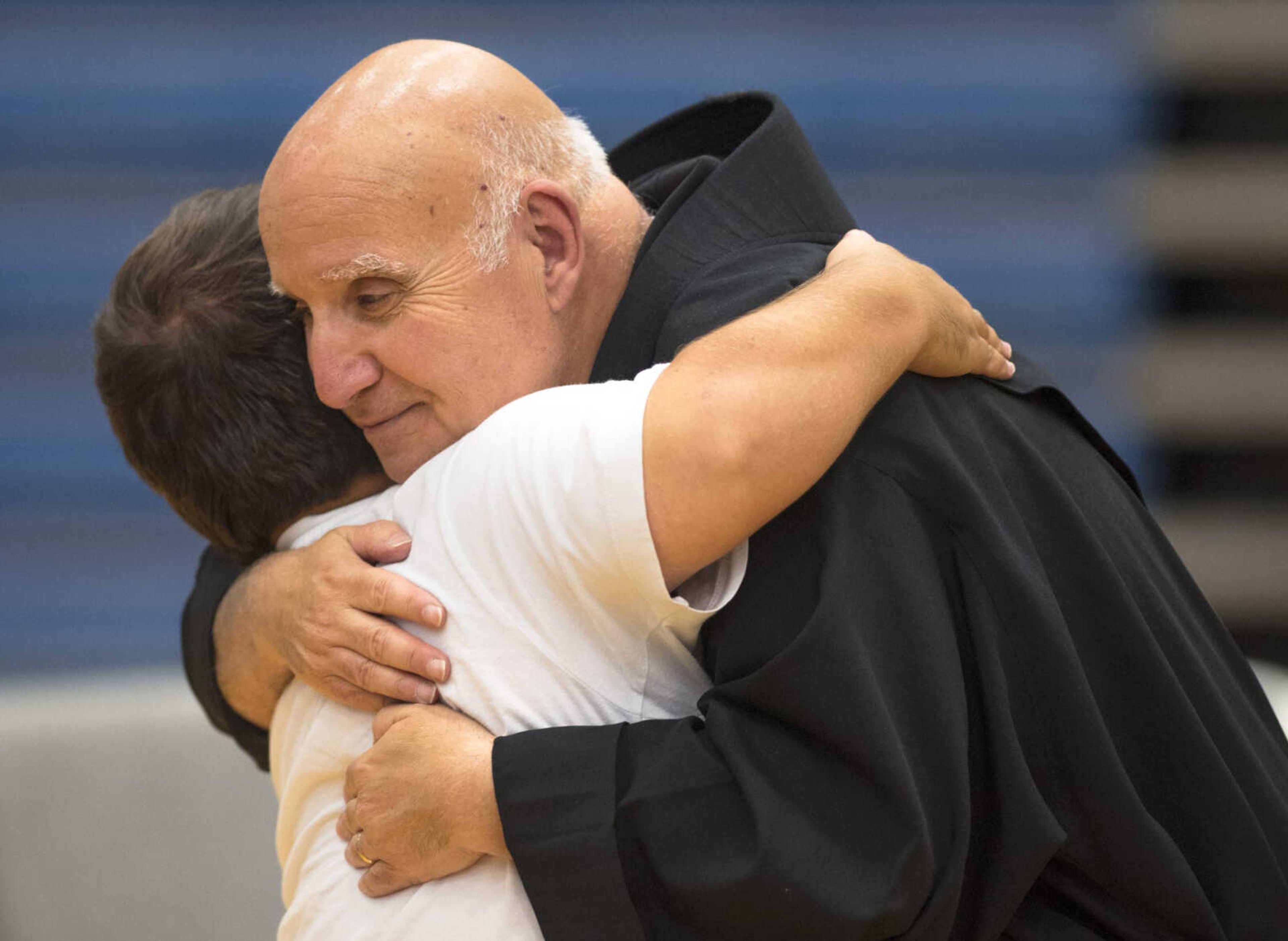 Notre Dame Regional High School’s former principal Brother David Anthony Migliorino, OSF, hugs Notre Dame alumnus Mitchell Ulrich during a send-off ceremony Sunday at Notre Dame Regional High School in Cape Girardeau.