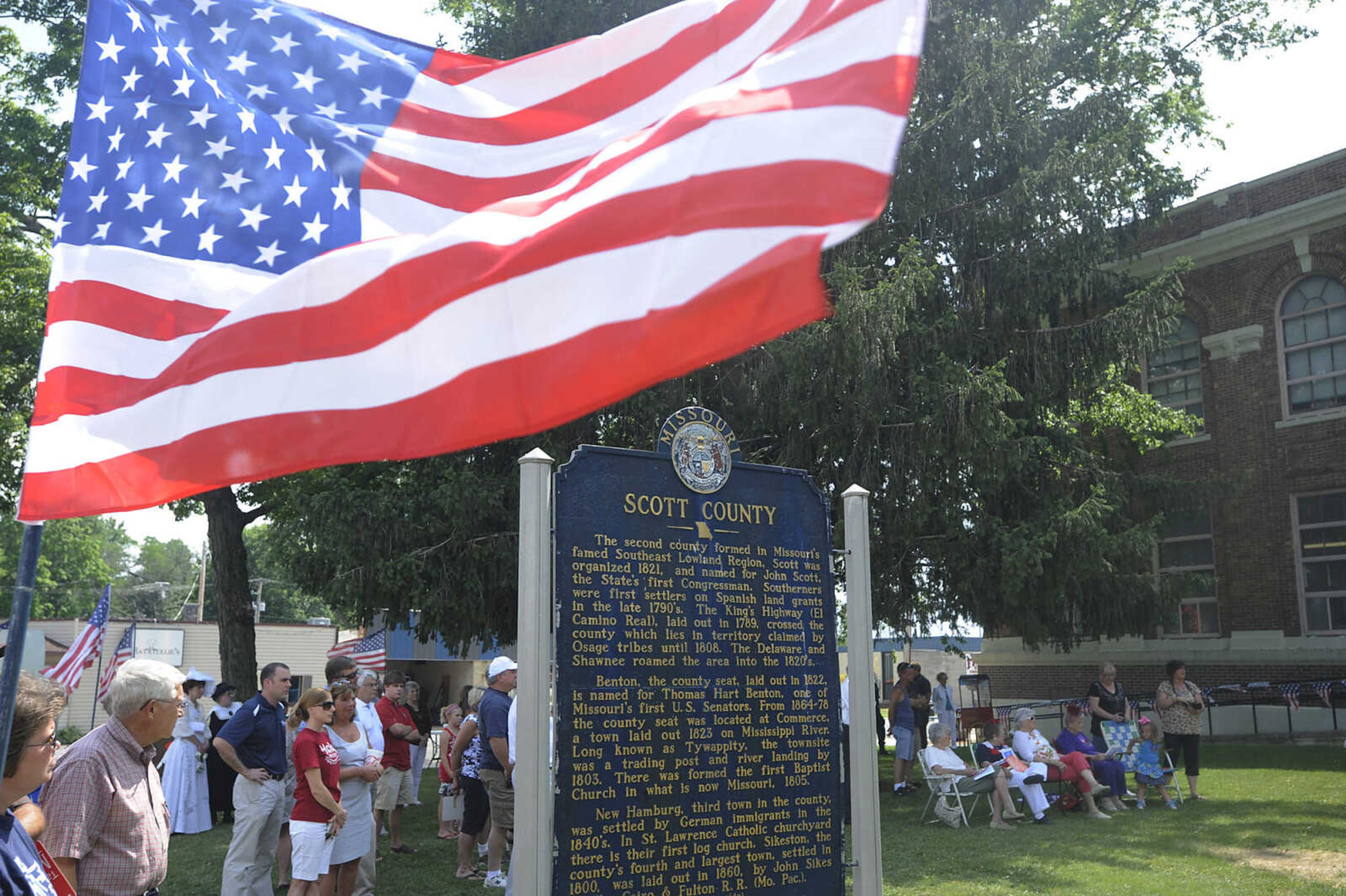 Crowds seek the shade during a celebration in honor of the centennial of the Scott County Courthouse in Benton Saturday, June 16. The building, the sixth courthouse for Scott County, was designed by Henry H. Hohenschild in 1912 and dedicated on April 20, 1914.  The courthouse was placed on the National Register of Historic Places in January 2004.