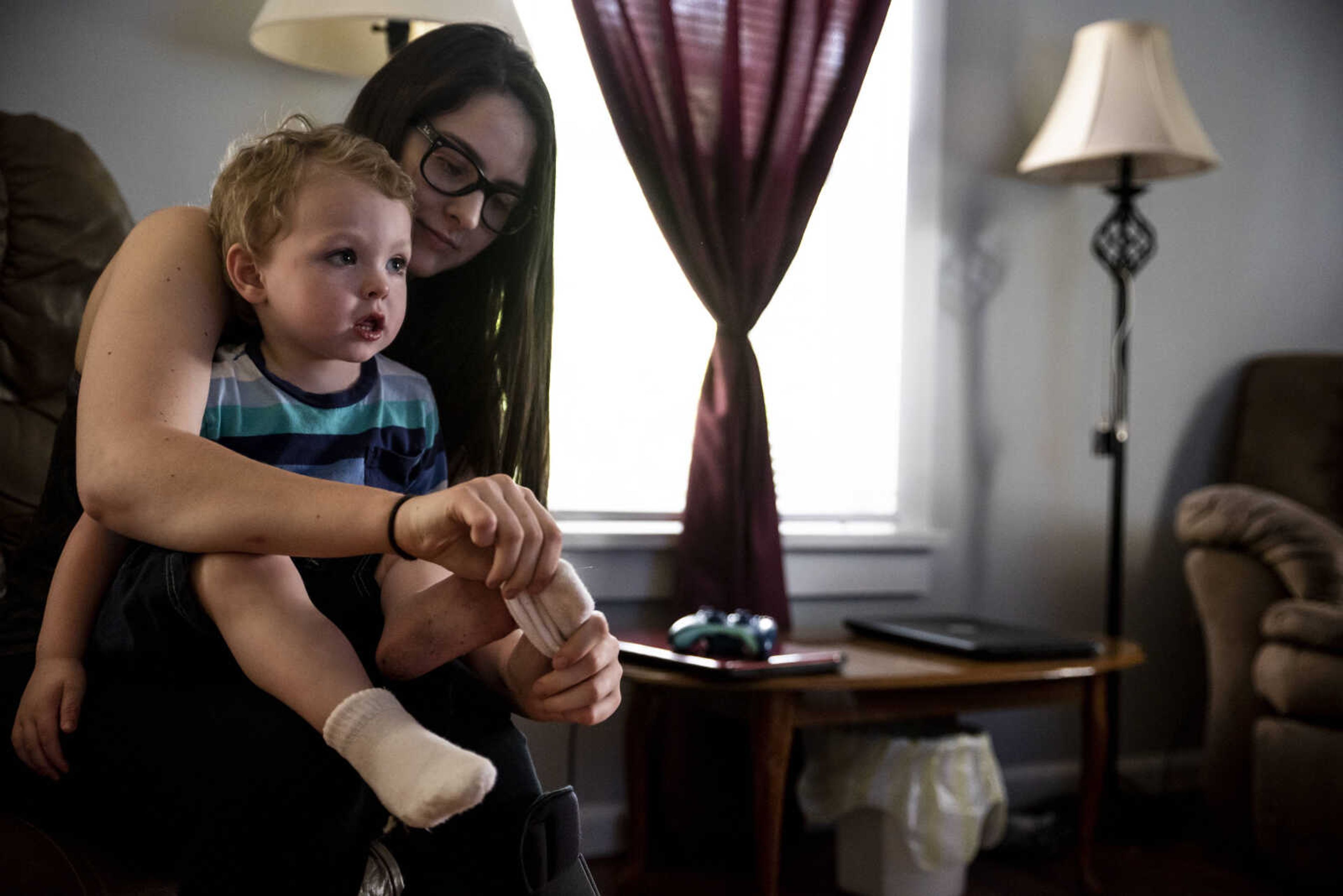 Emily Medlock puts socks on her son, Phoenix Young, 2, before taking him outside to play at home Tuesday, May 7, 2019, in Cape Girardeau.