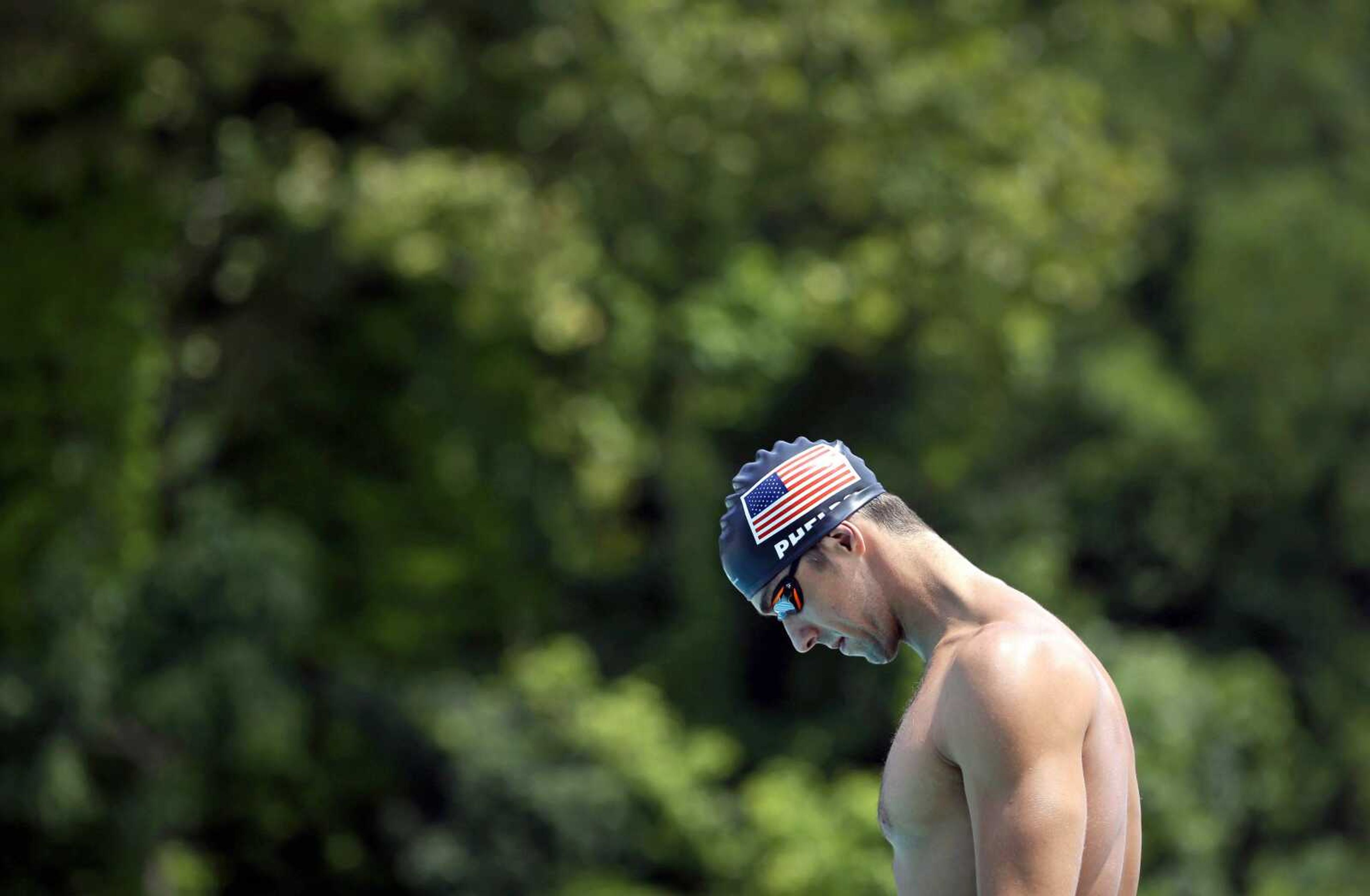 In this July 31, 2014 photo, Michael Phelps pauses before a training session at Meadowbrook Aquatic and Fitness Center in Baltimore. This is where Phelps put in most of the work to become the most decorated athlete in Olympic history. This is where he's looking to add to that legacy after an aborted retirement, his eyes firmly on the Rio Games two years away. (AP Photo/Patrick Semansky)