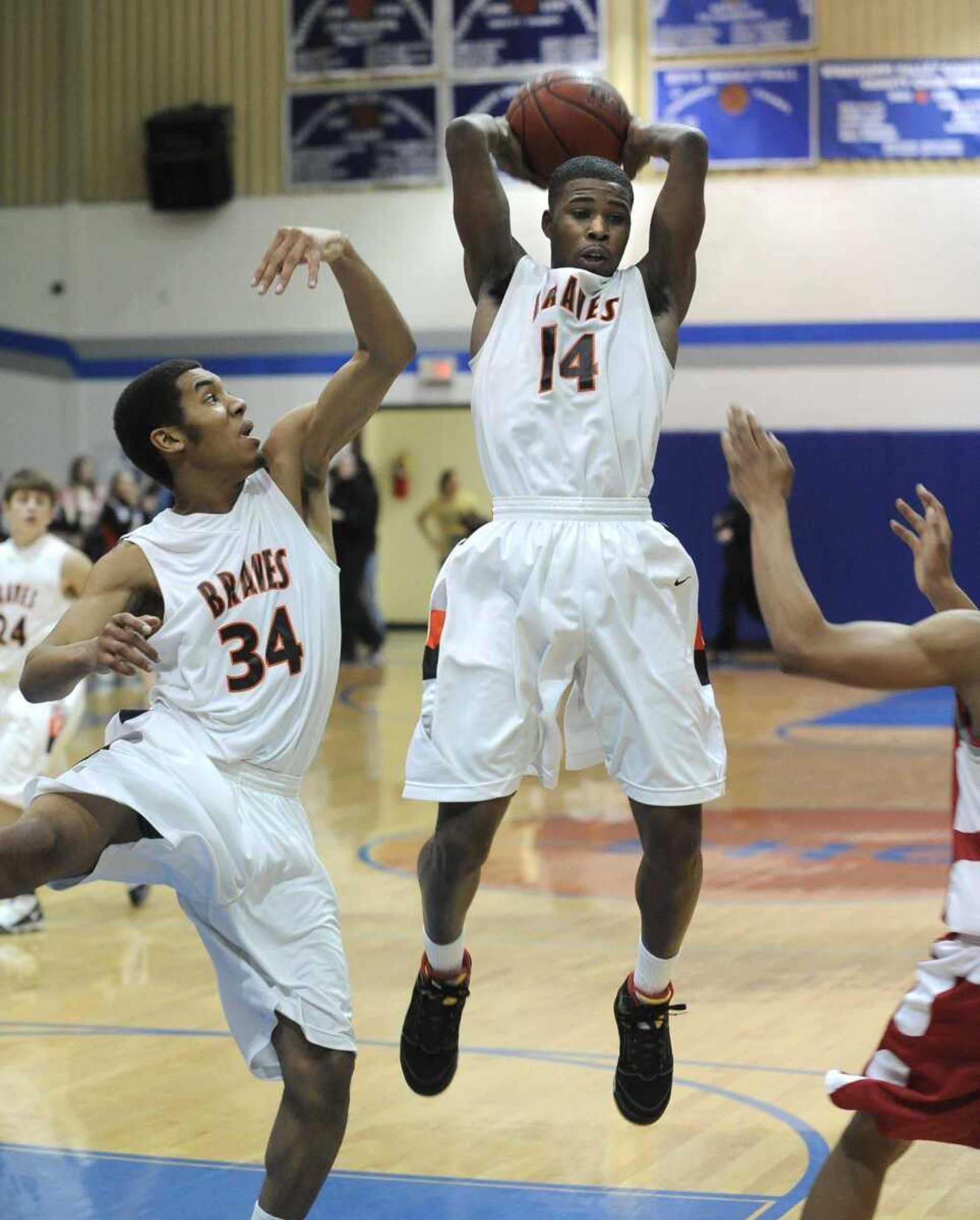 Scott County Central's Bobby Hatchett grabs a rebound before teammate Calvin Porter during the first quarter of the Class 1 District 3 championship game against Richland Thursday.