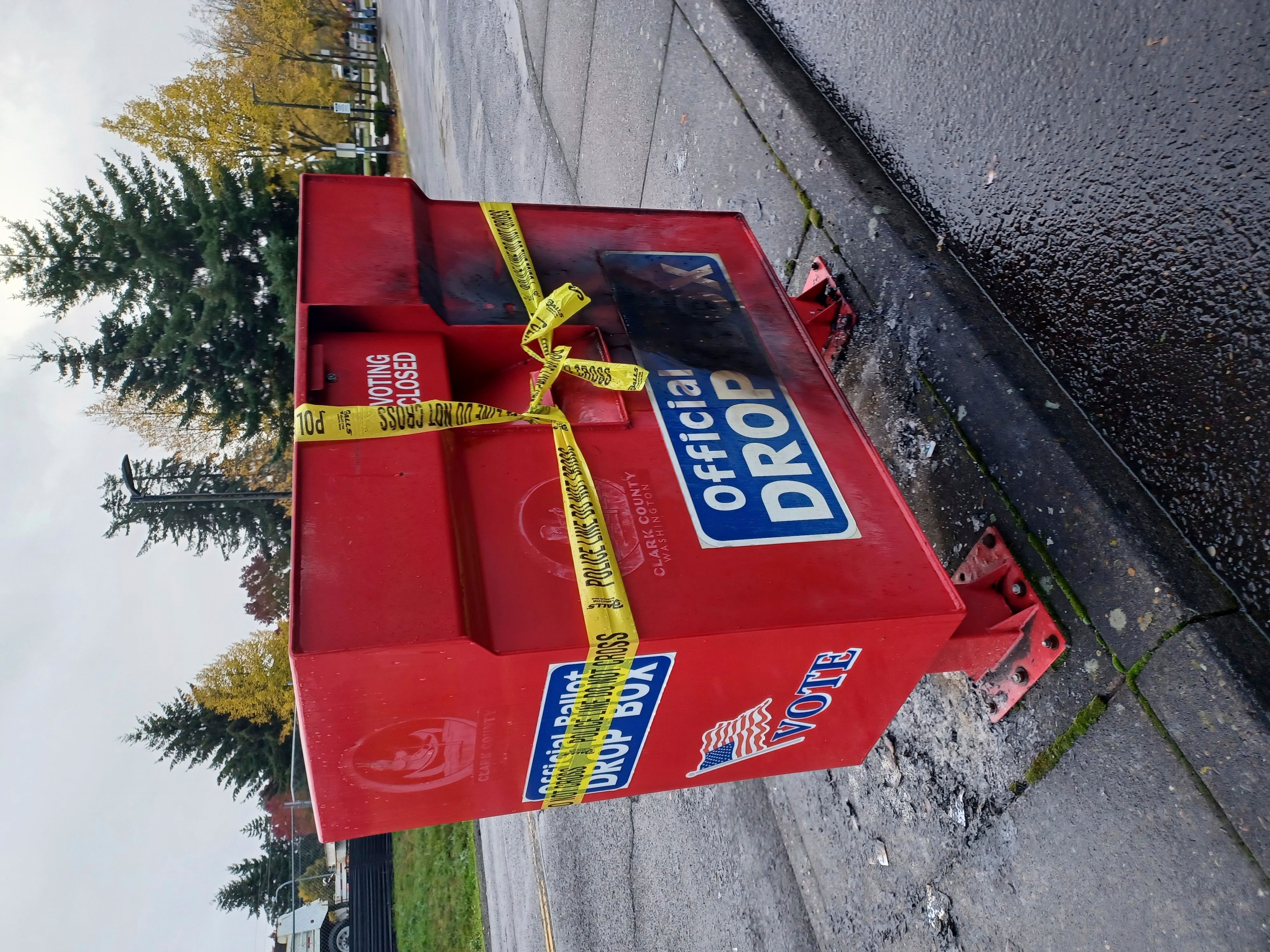 Police tape surrounds a ballot drop box damaged by a fire on Monday, Oct. 28, 2024, in Vancouver, Wash. (Monika Spykerman/The Columbian via AP)