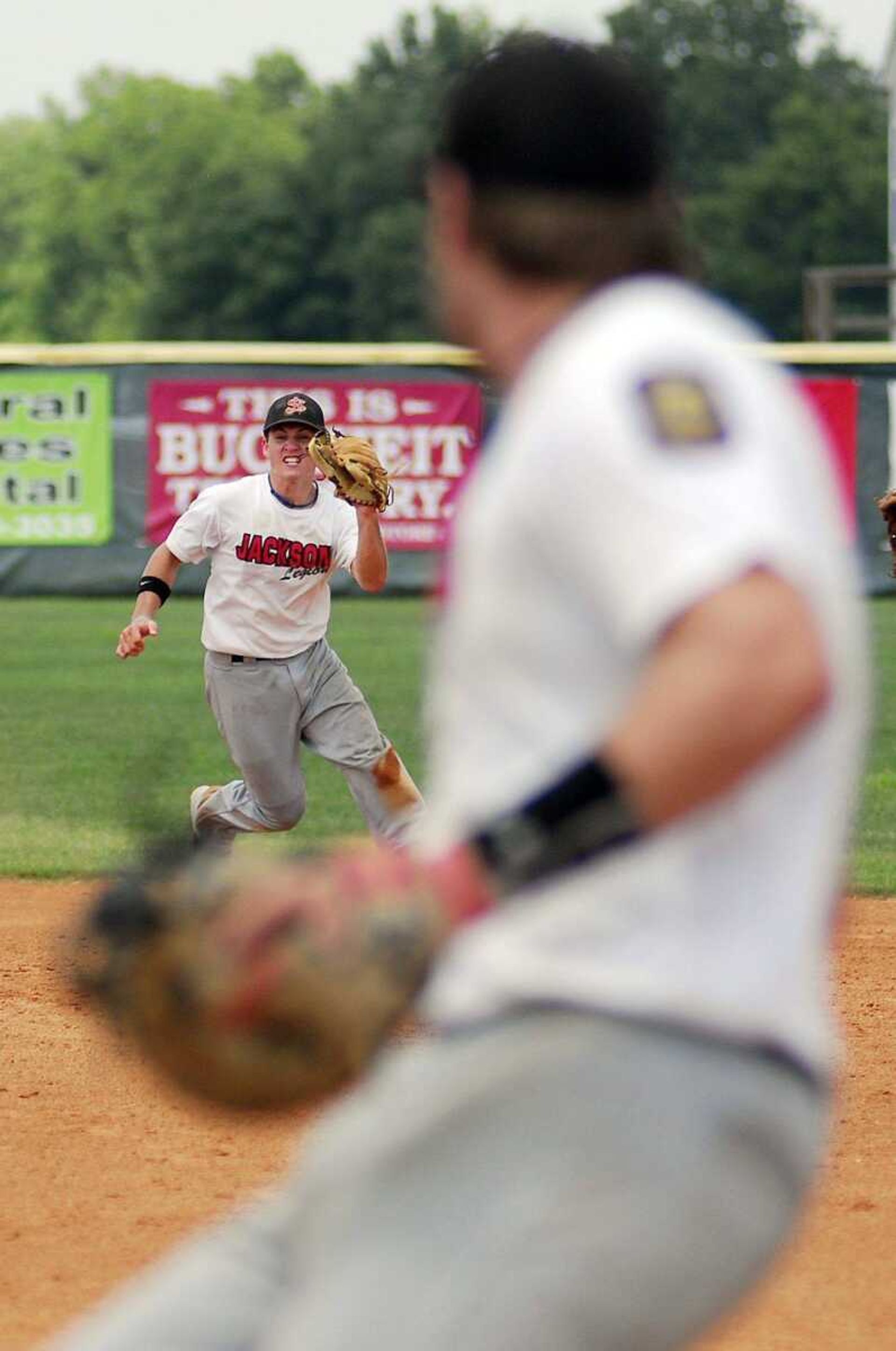 Jackson's Kendall Fay fields a ground ball as teammate Jake Conklin readies for the play at first Saturday, July 17, 2010 during their game against Poplar Bluff at Notre Dame Regional High School. (Laura Simon)