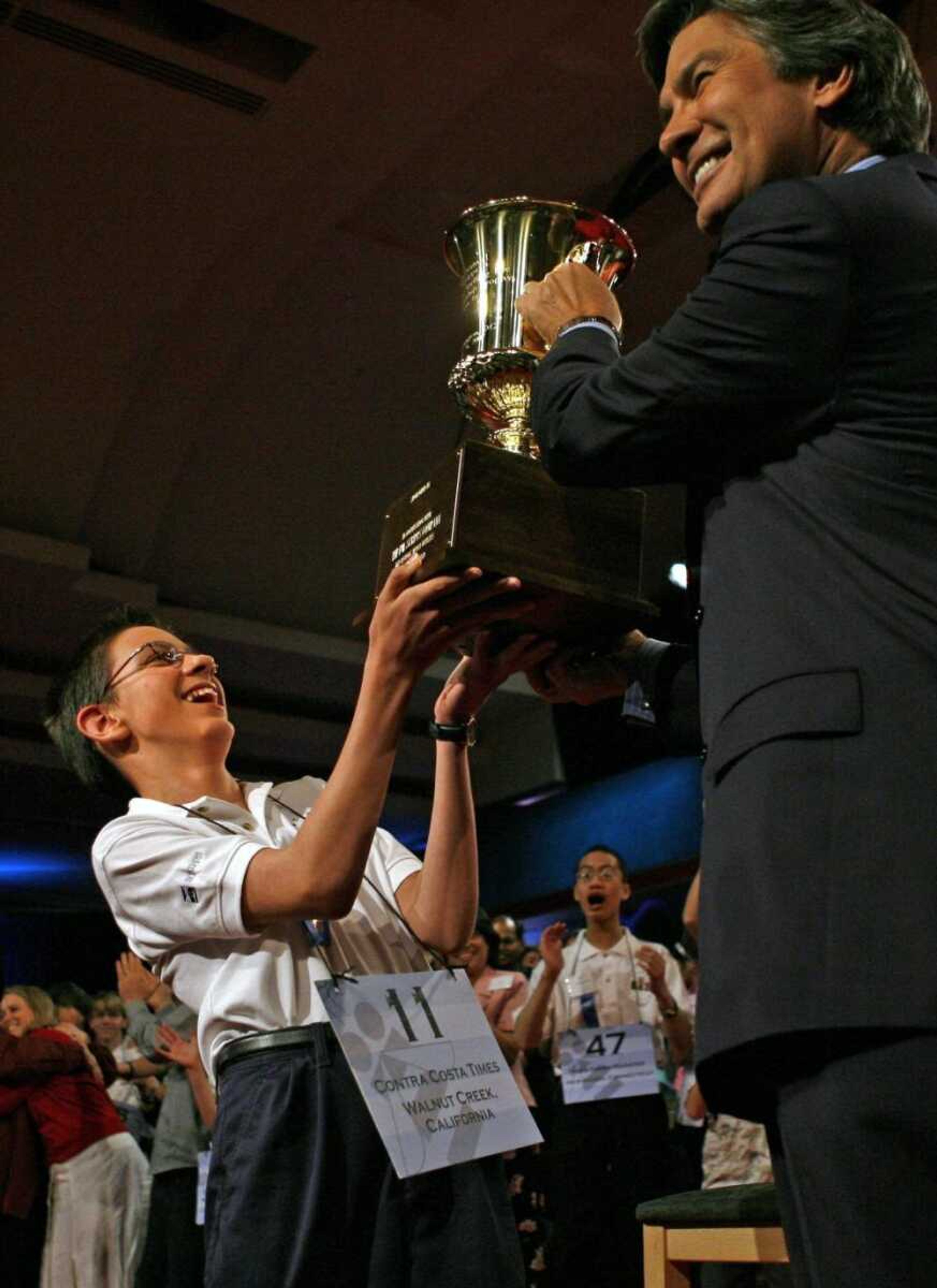 Evan M. O'Dorney, 13, of San Ramon, Ca., accepted his trophy from Kenneth W. Lowe, president of the E.W. Scripps Company, after he won the 2007 Scripps National Spelling Bee in Washington, D.C. on Thursday with the word "serrefine." (Jacquelyn Martin ~ Associated Press)