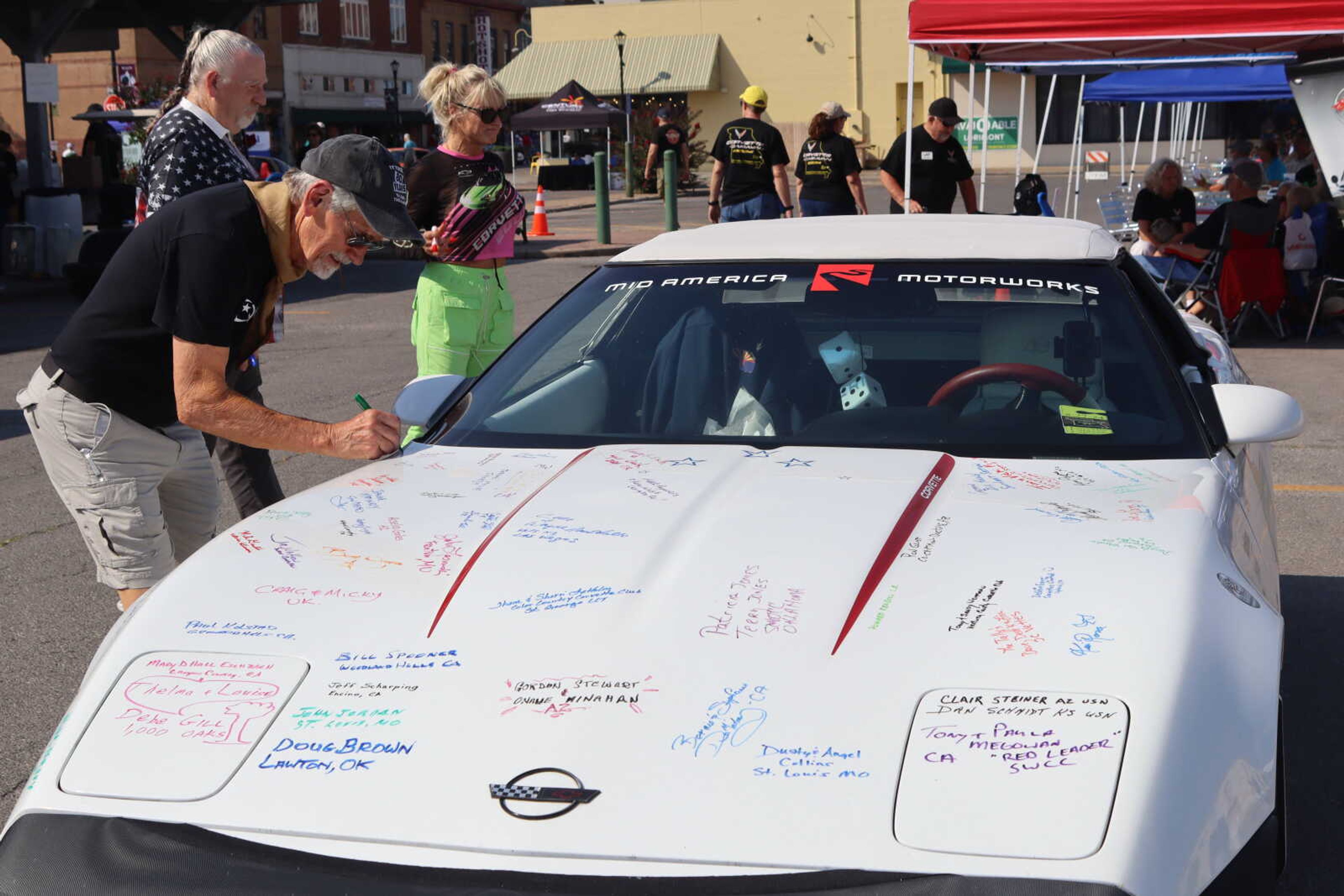 Jim Morgan signs his name on Corvette.